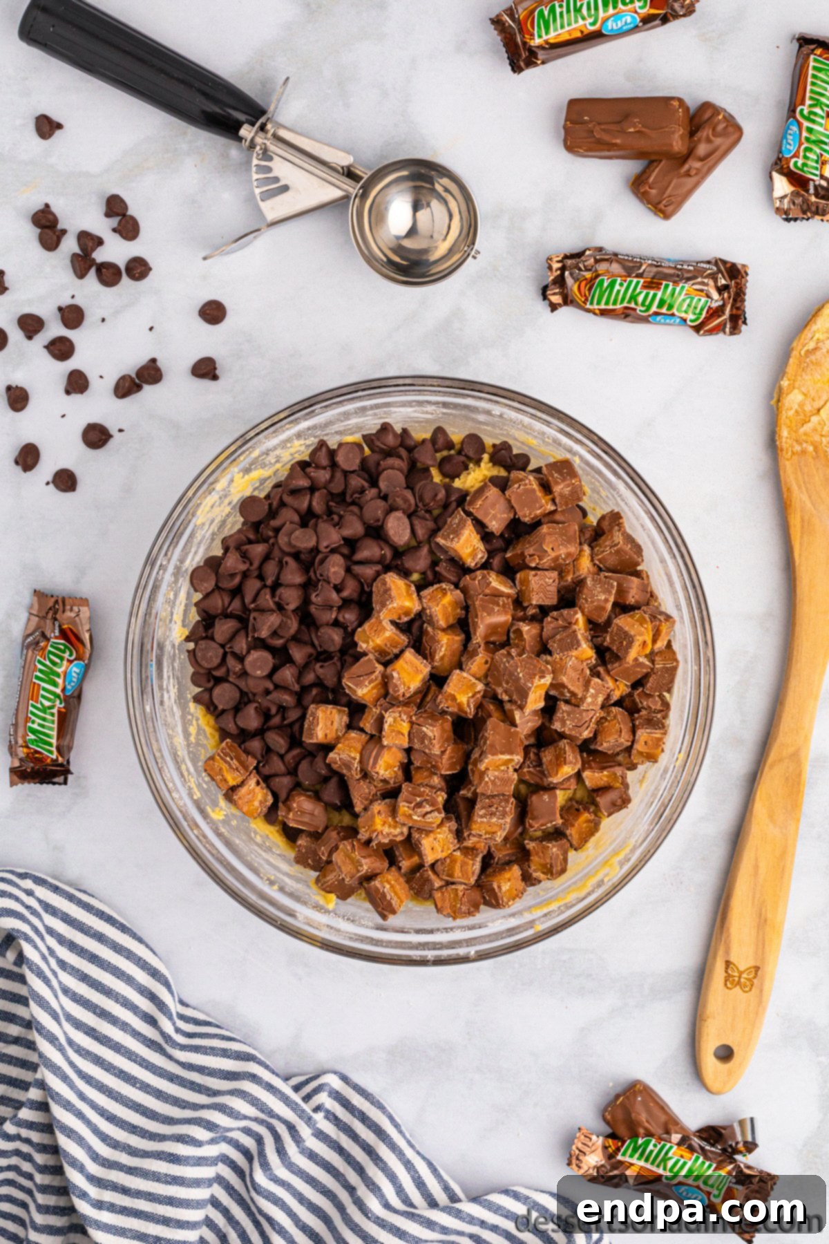 Nougat Caramel Dream Cookies 8 Chopped Milky Way candy bars being folded into the prepared cookie dough.