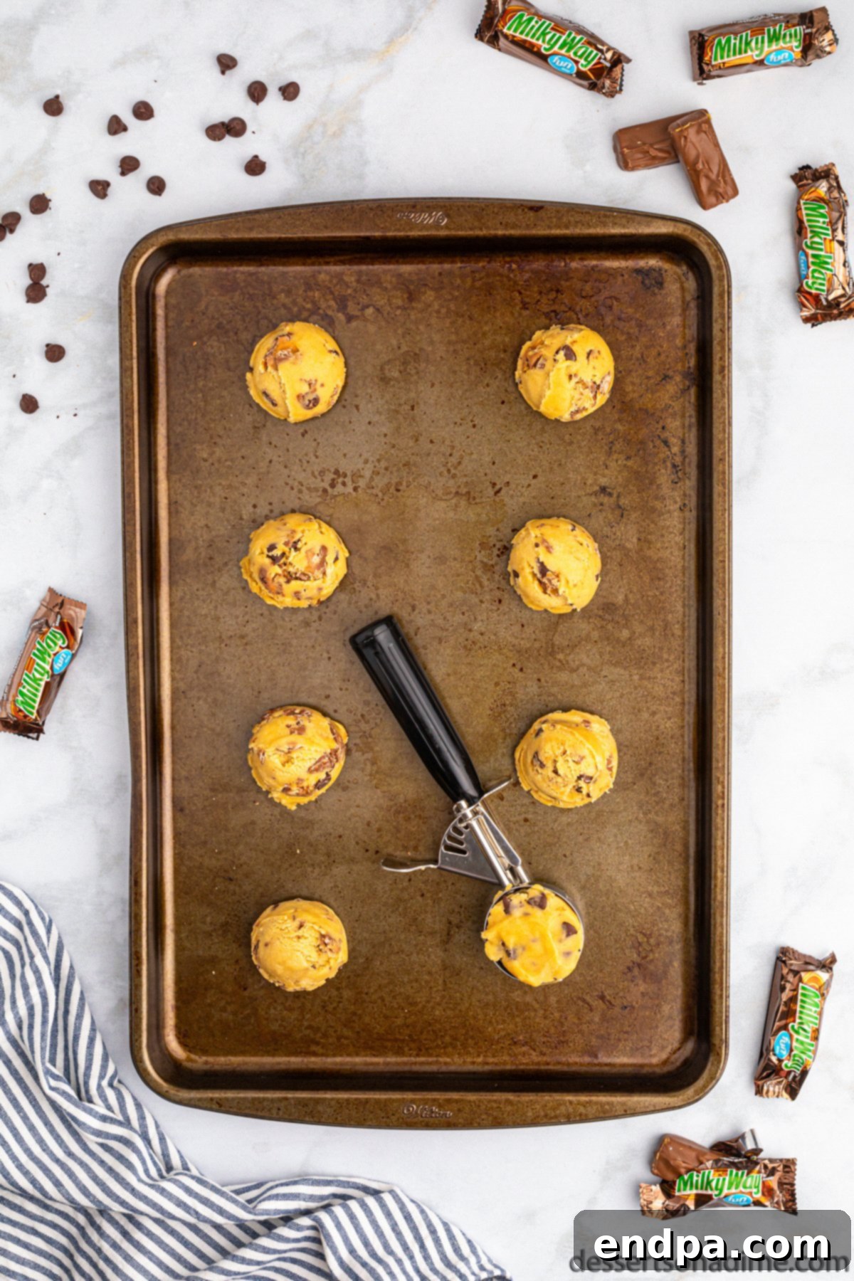 Nougat Caramel Dream Cookies 10 Cookie dough balls neatly scooped and arranged on a parchment-lined baking sheet, ready for baking.