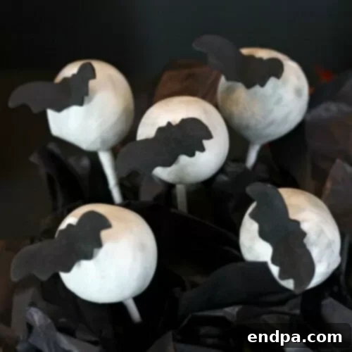 Spooktacular Cake Pops 10 Whimsical flying bat cake pops with dark bats against a light 'moon' background.