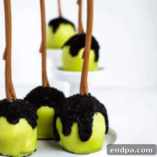Spooktacular Cake Pops 14 Poison apple cake pops, shiny black with red stems, evoking a classic fairytale Halloween theme.
