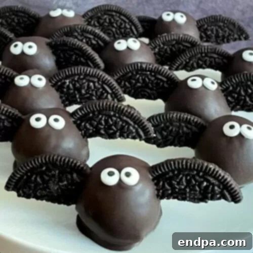 Spooktacular Cake Pops 18 Halloween bat cake pops made with chocolate cookies for wings and candy eyes, against a dark background.