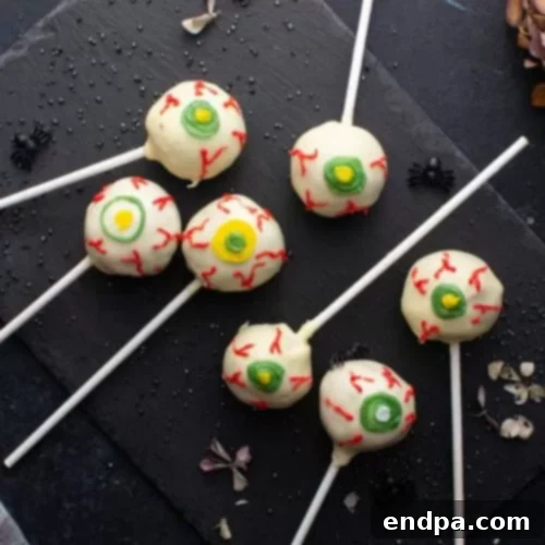 Spooktacular Cake Pops 19 Ghoulish eyeball cake pops with detailed red veins on white chocolate, creating a realistic eye effect.