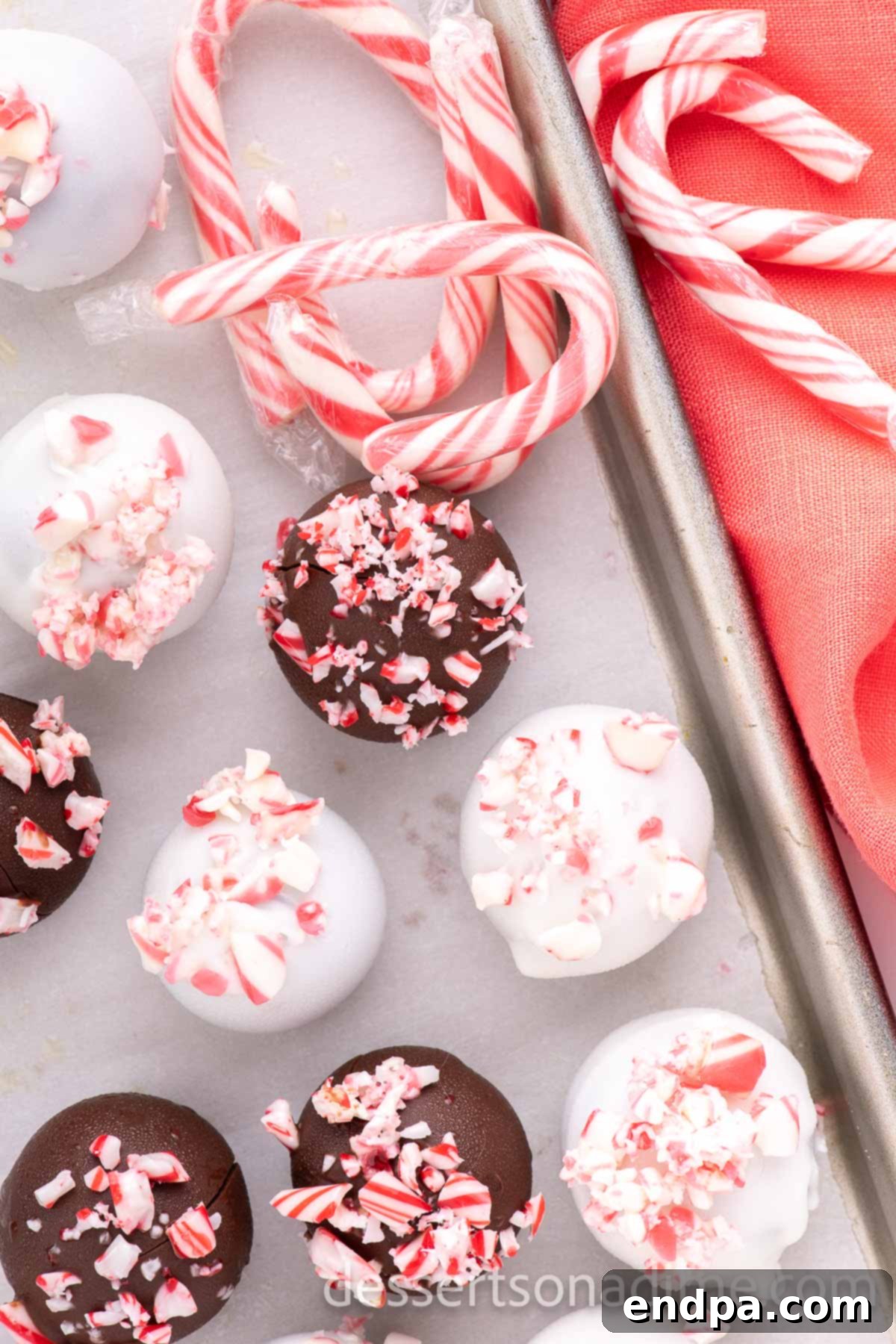 Cool Mint Oreo Truffles 11 Peppermint oreo balls on a baking sheet after being dipped and topped with crushed candy canes.