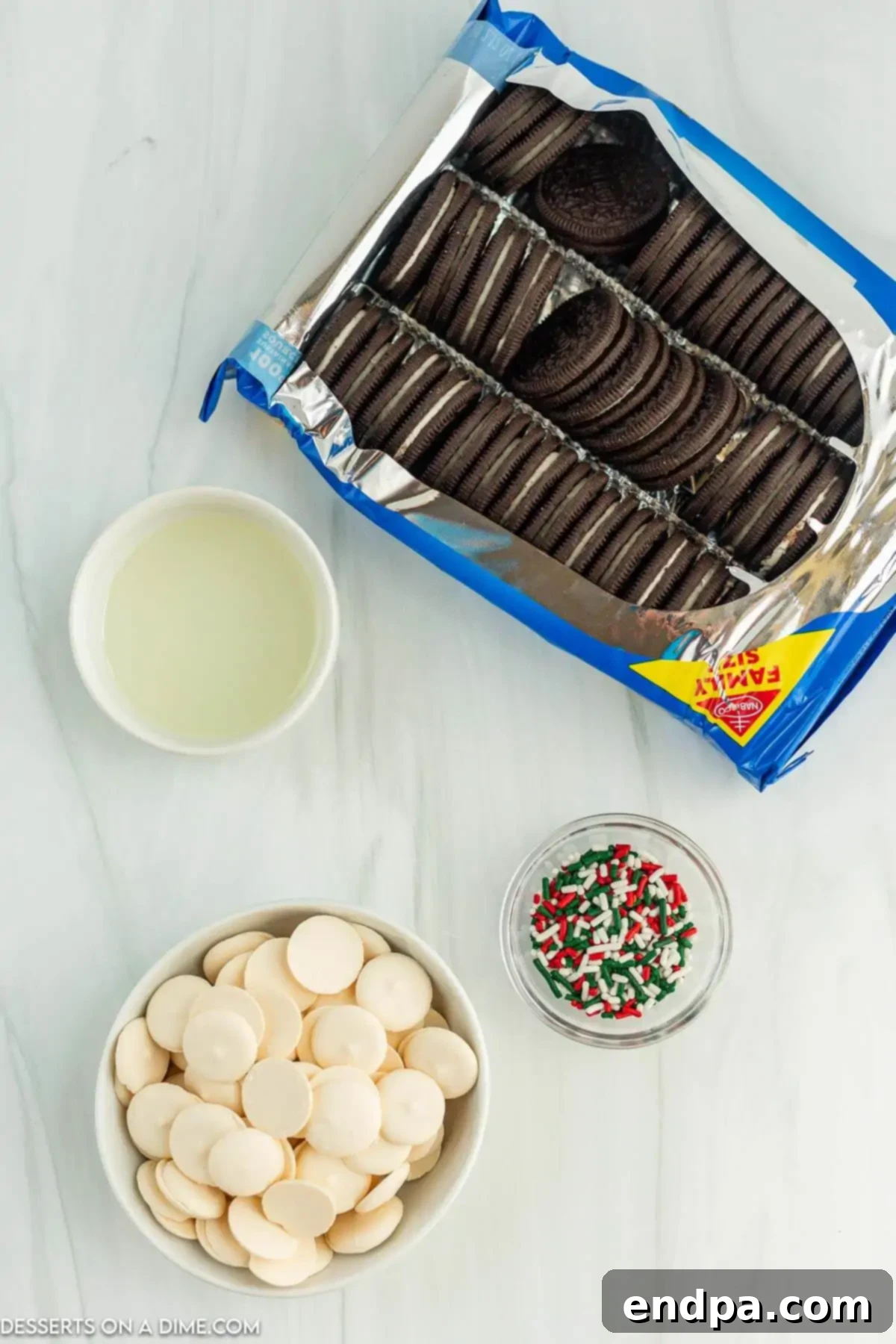 Holiday Oreo Delights 3 Layout of ingredients for Christmas white chocolate Oreos, including cookies, candy melts, oil, and sprinkles.