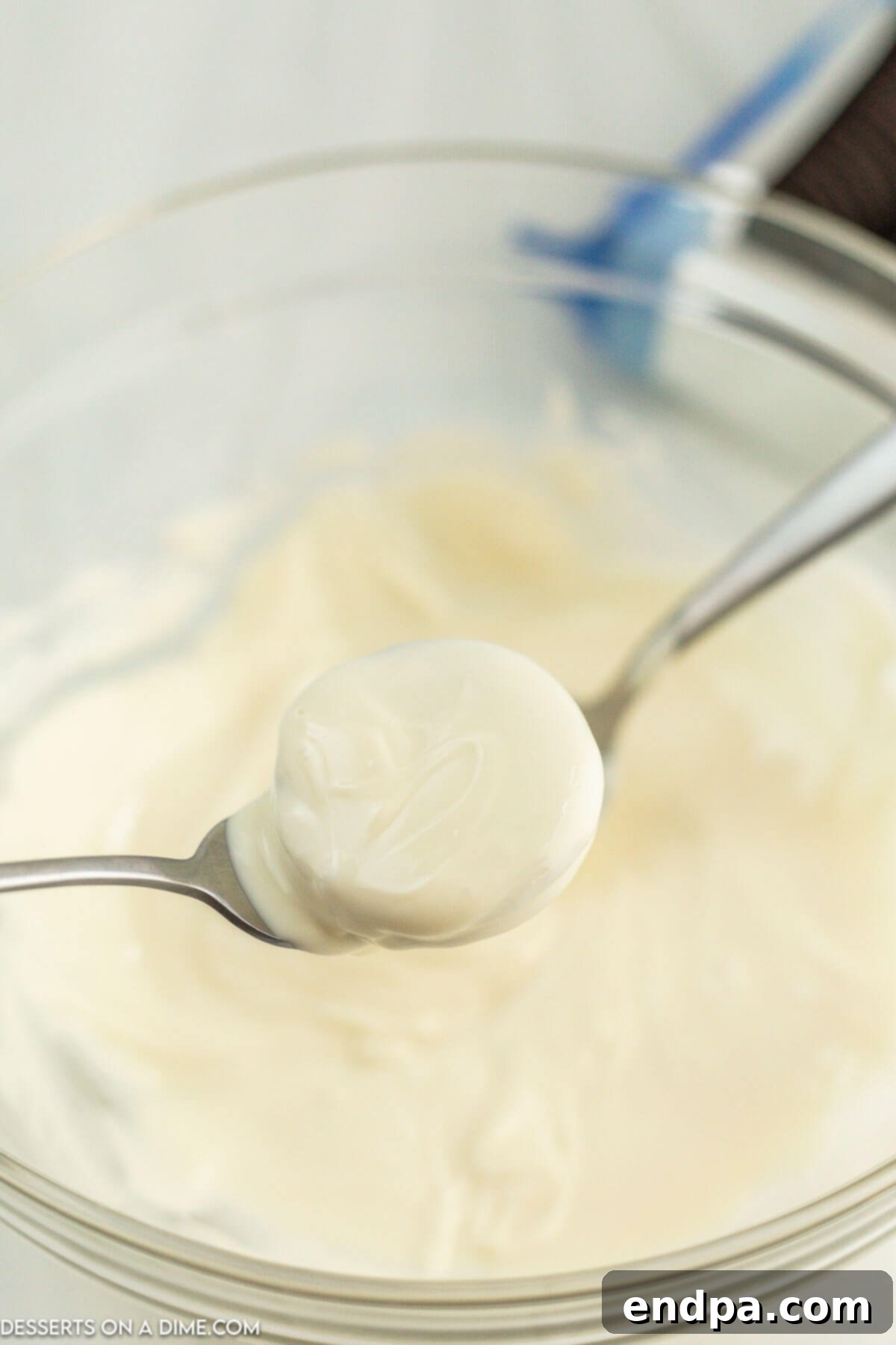 Holiday Oreo Delights 5 An Oreo cookie being dipped into melted white chocolate with a fork.