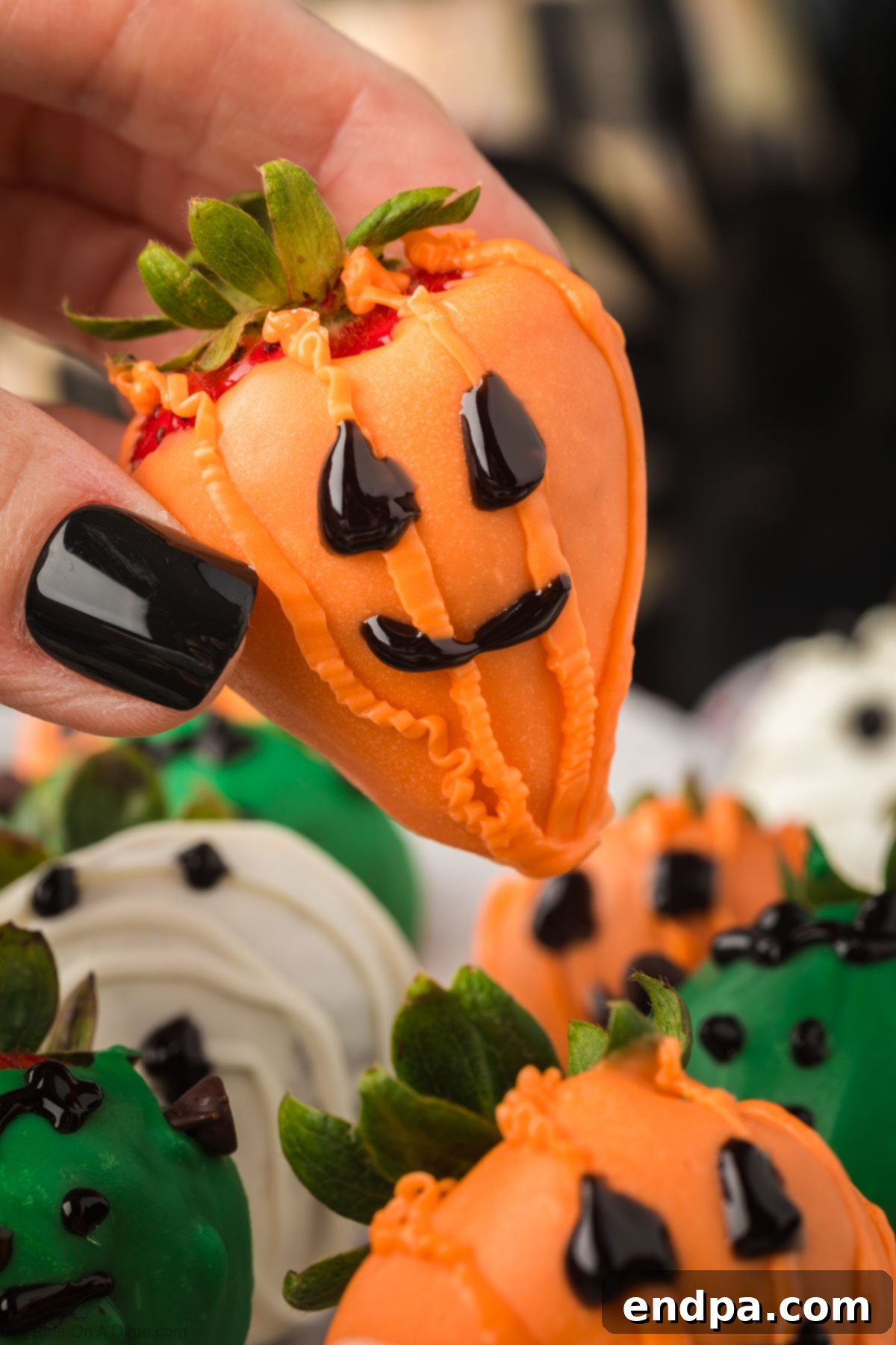 A black platter showcasing beautifully decorated Halloween Chocolate Covered Strawberries in various designs, ready to be served.