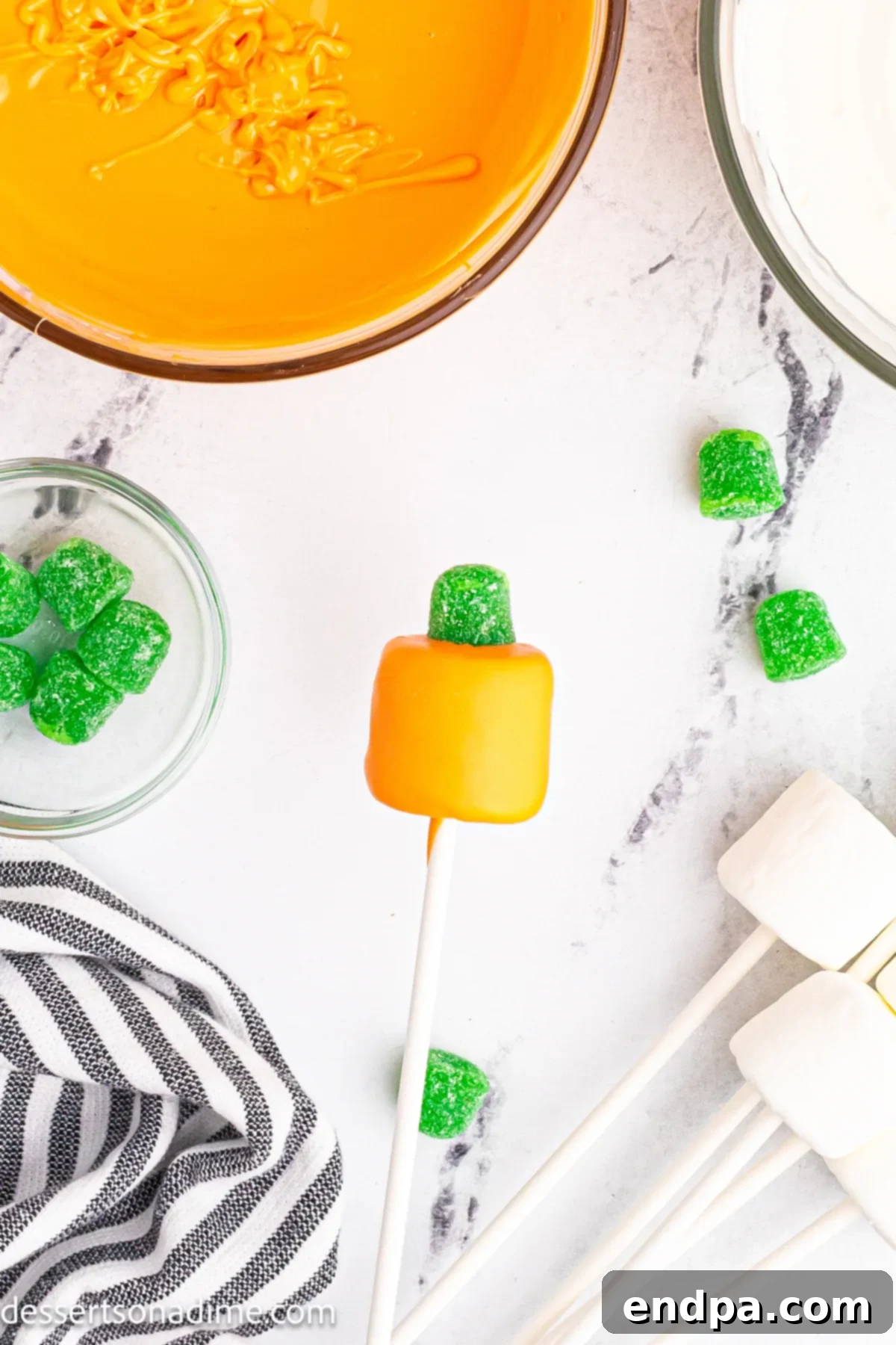 Marshmallow dipped in orange and topped with a green gum drop. 