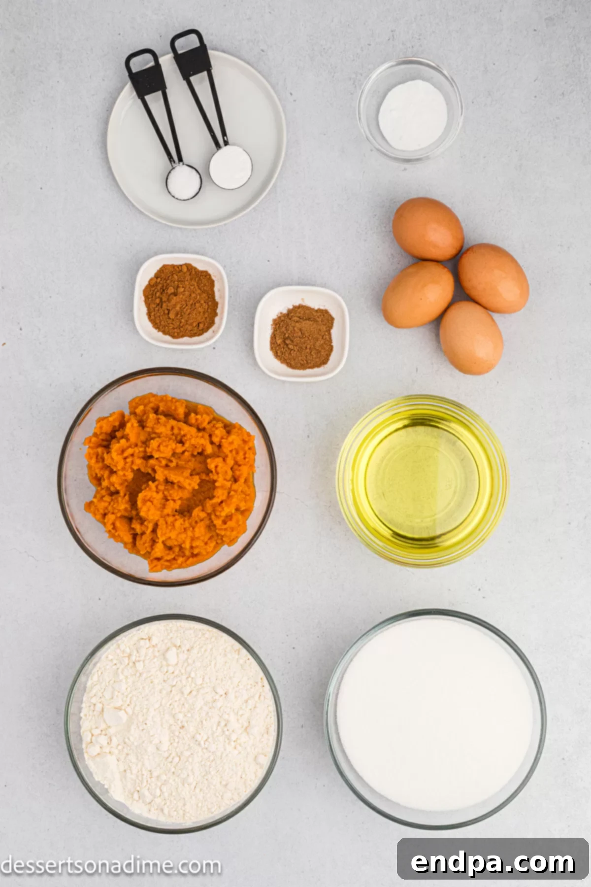 Ingredients for Pumpkin cake - flour, baking soda, eggs, pumpkin puree, butter, cream cheese, vanilla, powdered sugar arranged on a rustic wooden surface.