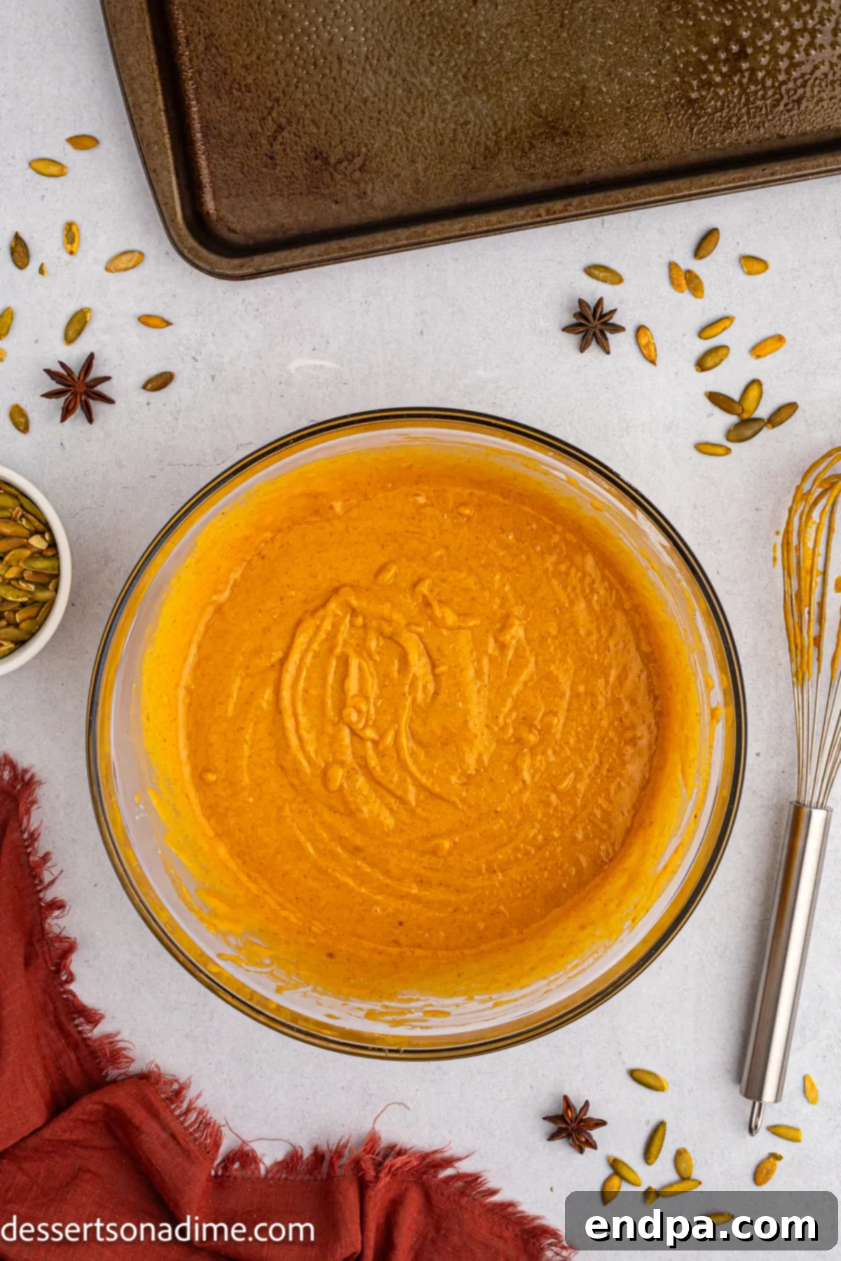 Pumpkin puree combined with wet ingredients in a bowl.