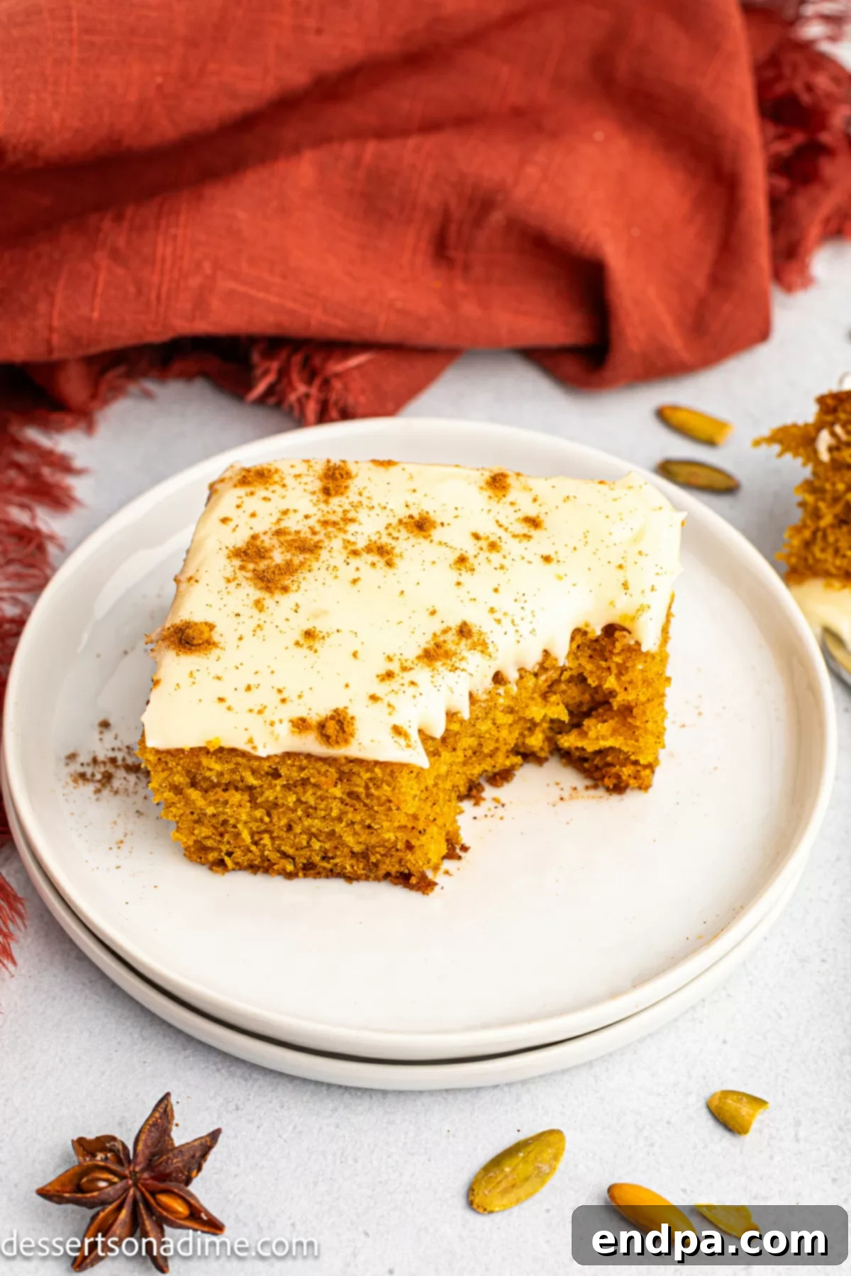 Pumpkin cake sliced on a plate, showing the moist texture and creamy frosting.