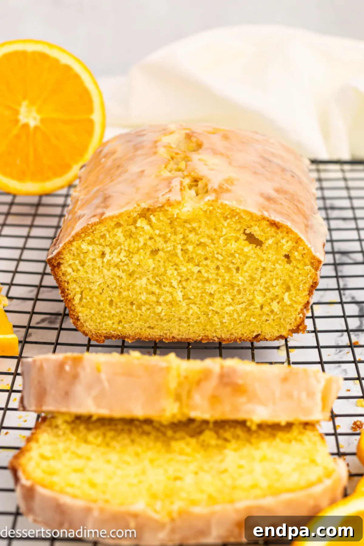 A freshly baked orange pound cake, beautifully glazed and sliced, ready to be served.
