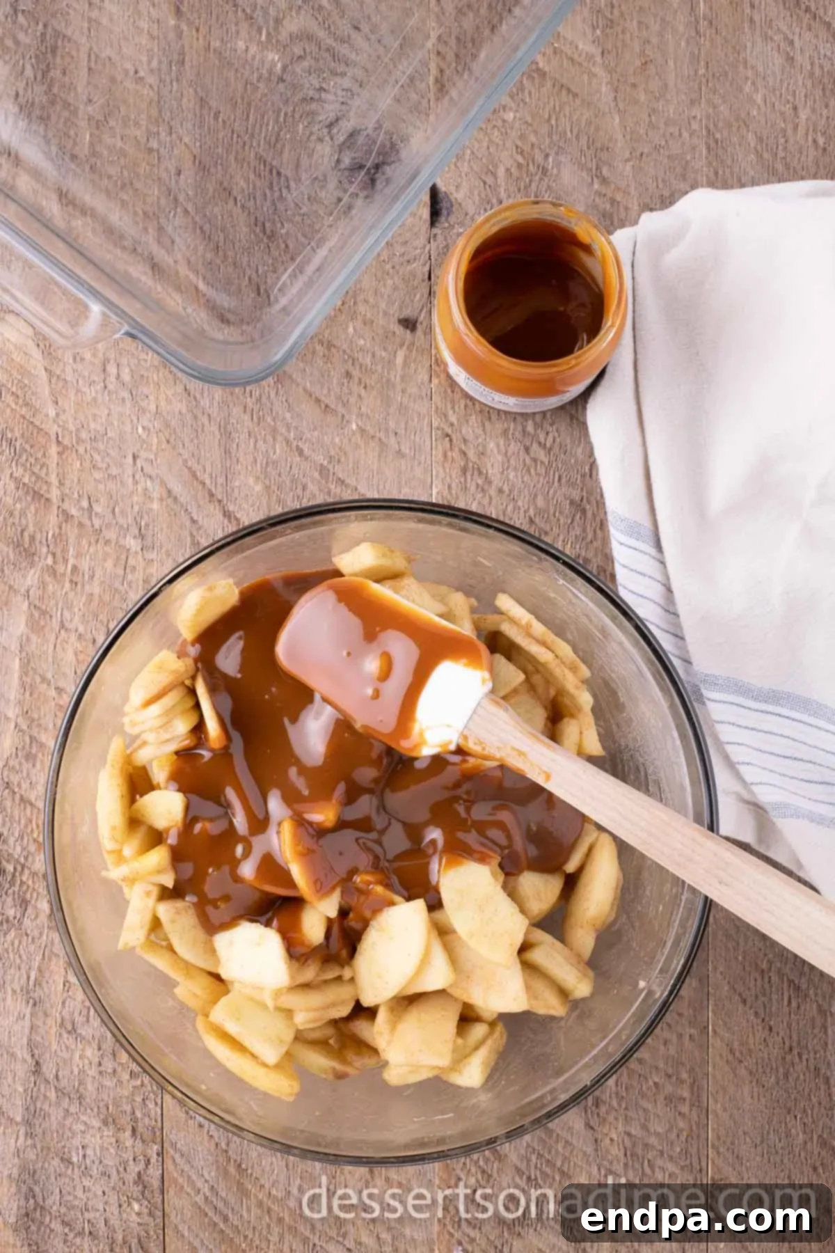 Caramel poured into mixing bowl with apples.