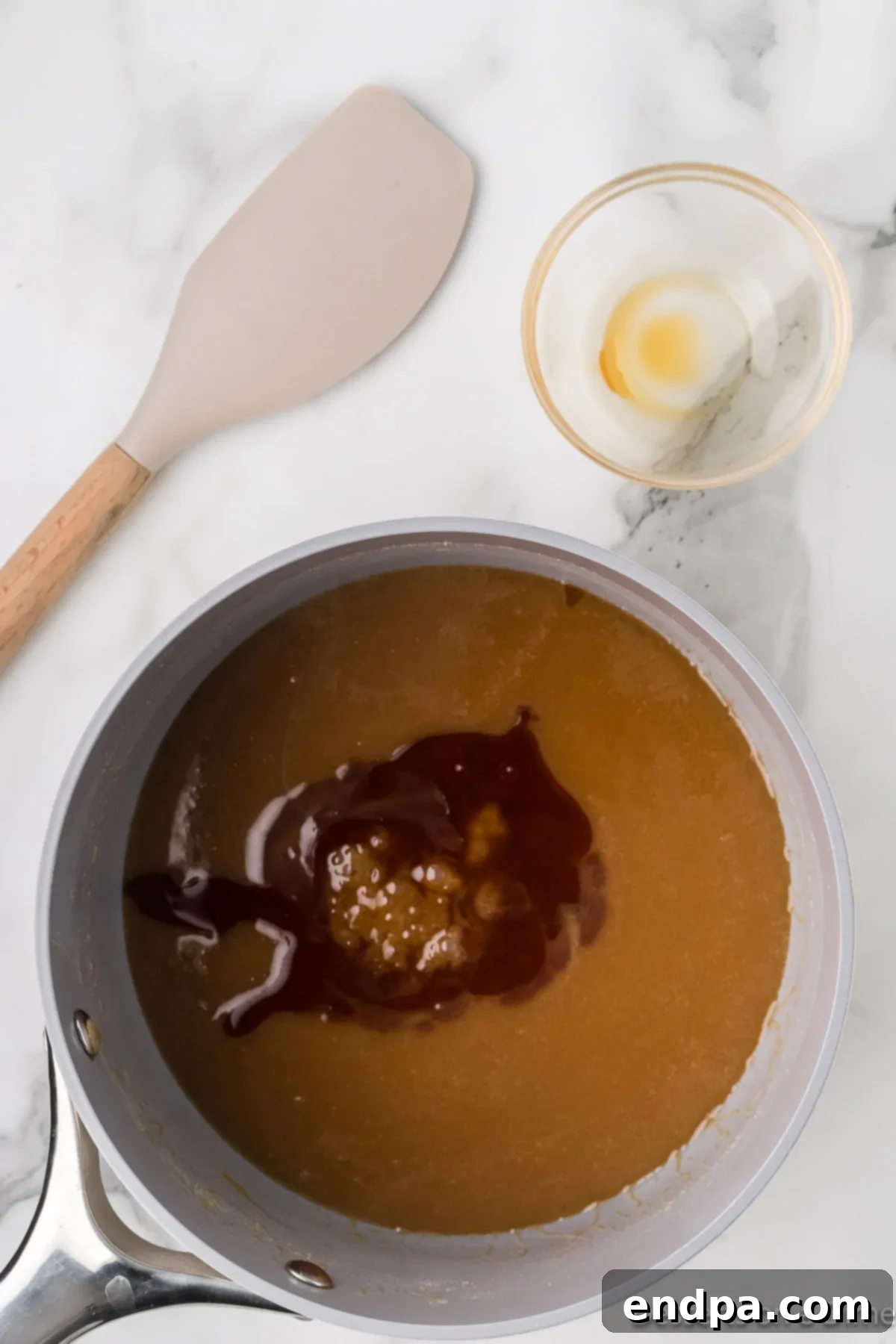 Decadent Homemade Caramel 5 Caramel mixture combined and vanilla extract being stirred in.