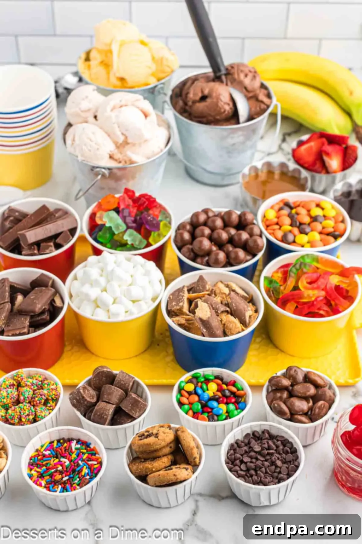 A vibrant selection of ice cream toppings, including chocolates, candies, and sauces, displayed in clear bowls.