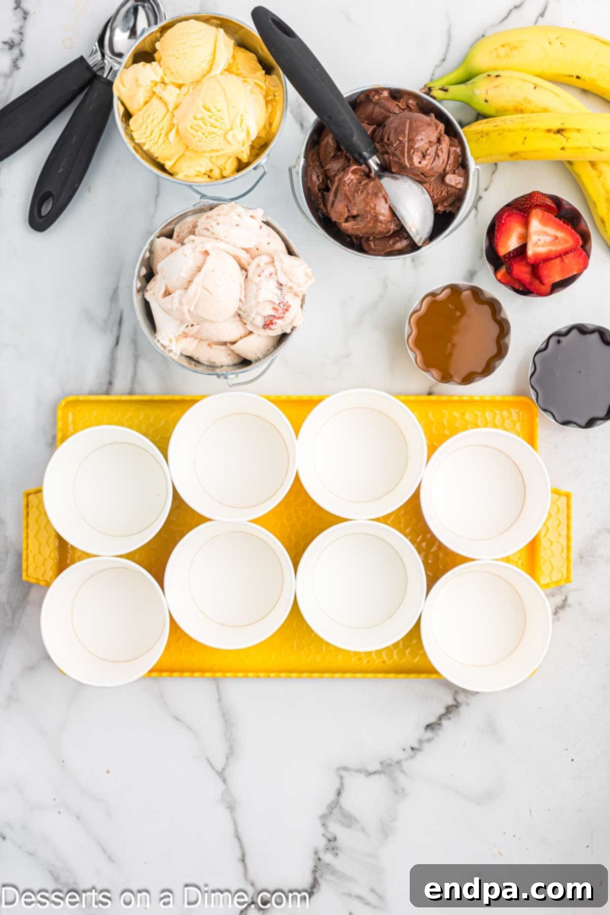 Various cups ready for serving ice cream, highlighting the organized setup of a sundae bar.