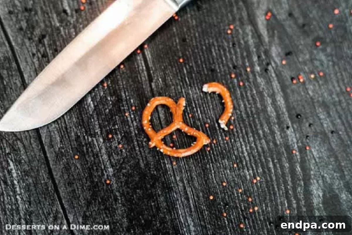 Carefully cutting the curved ends off pretzel twists to create perfect, bent spider legs for decorating mini brownies.