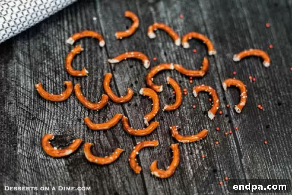A collection of perfectly cut pretzel pieces, with curved ends removed, meticulously prepared to be transformed into spider legs for a batch of mini brownies.