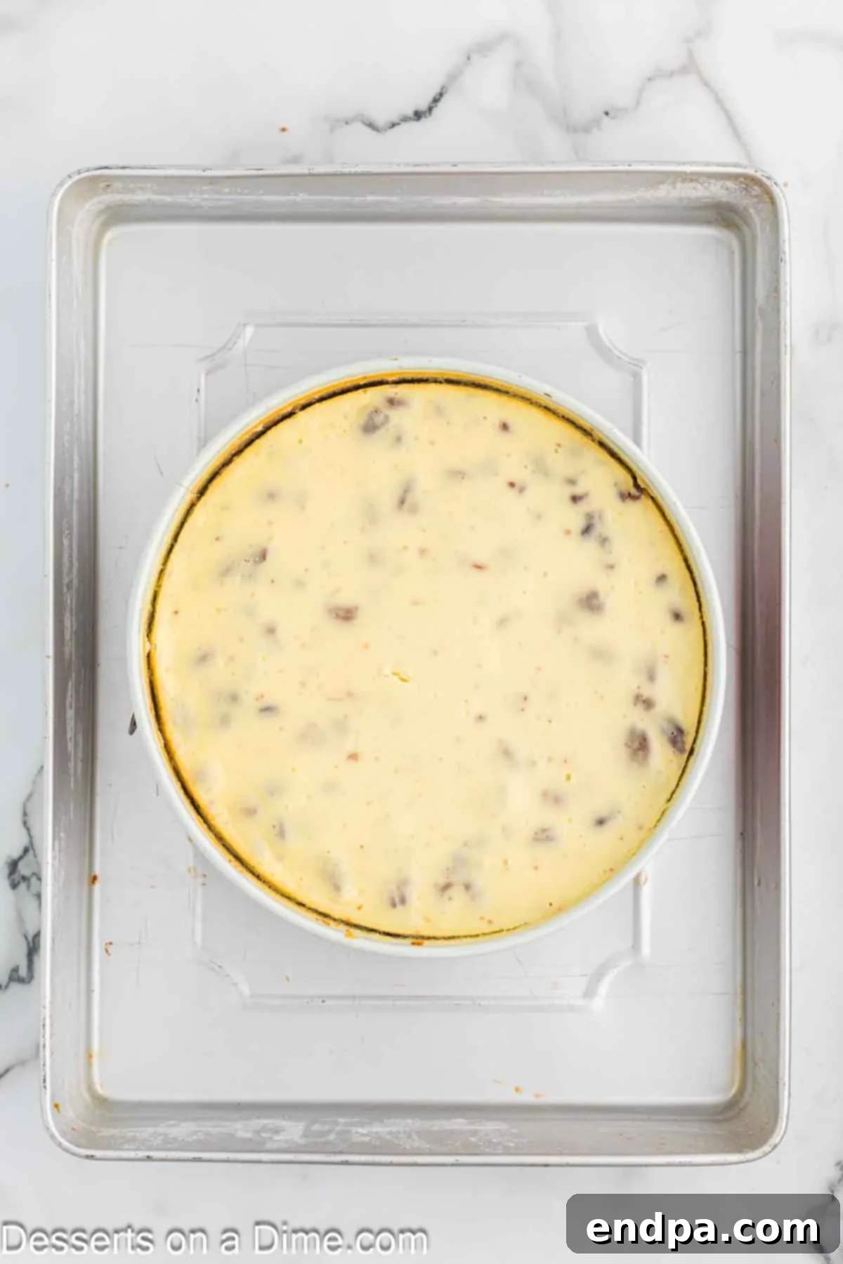 Golden Butter Pecan Cheesecake 11 A springform pan filled with smooth cheesecake batter, nestled within a larger roasting pan for a water bath, ready for baking.