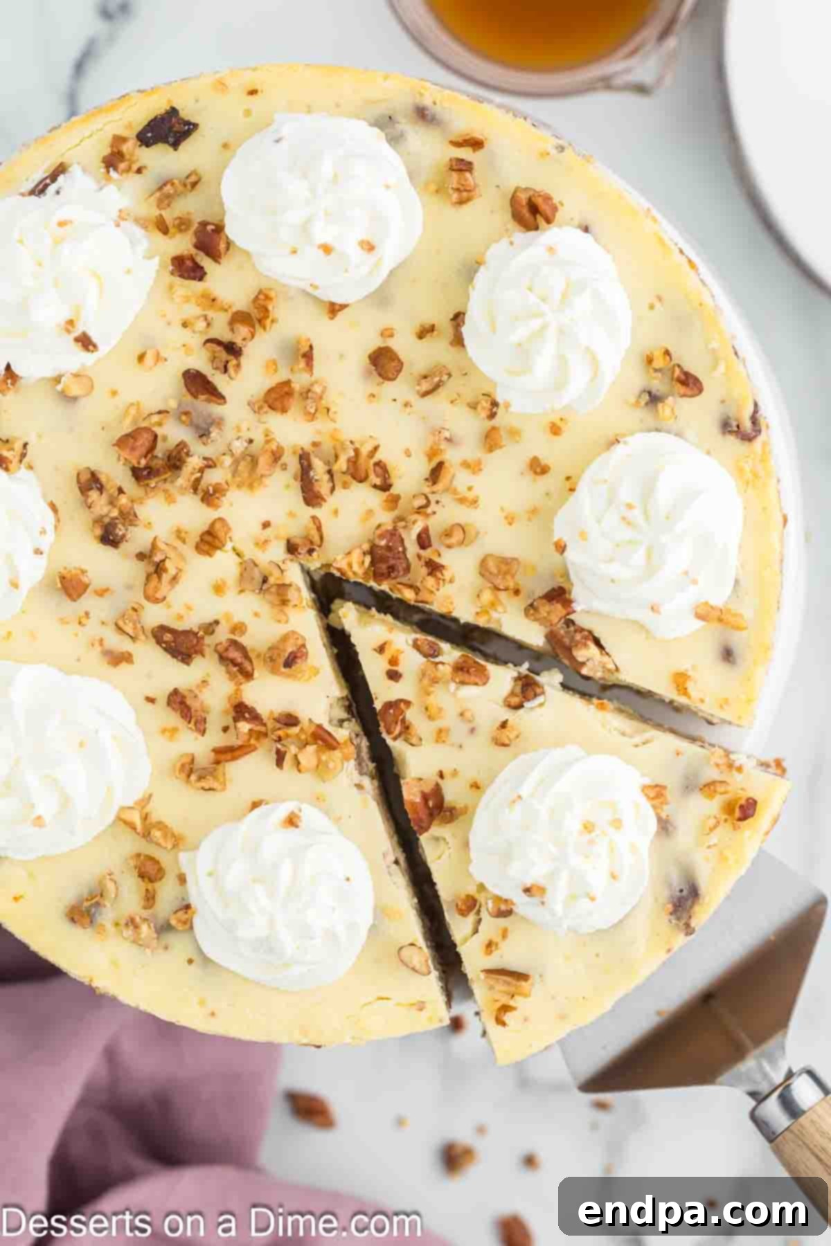 Golden Butter Pecan Cheesecake 12 A decadent butter pecan cheesecake being skillfully sliced, revealing its smooth, creamy interior and inviting texture.