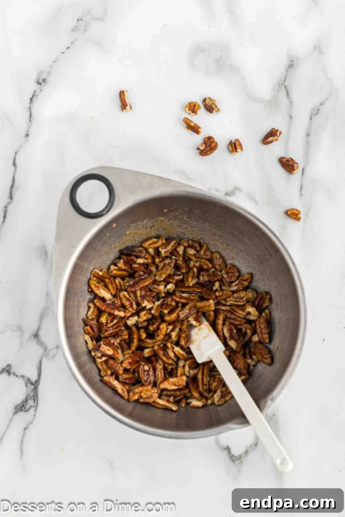 Golden Butter Pecan Cheesecake 4 A bowl containing chopped pecans mixed with brown sugar and melted butter, ready to be spread and toasted for the cheesecake topping.