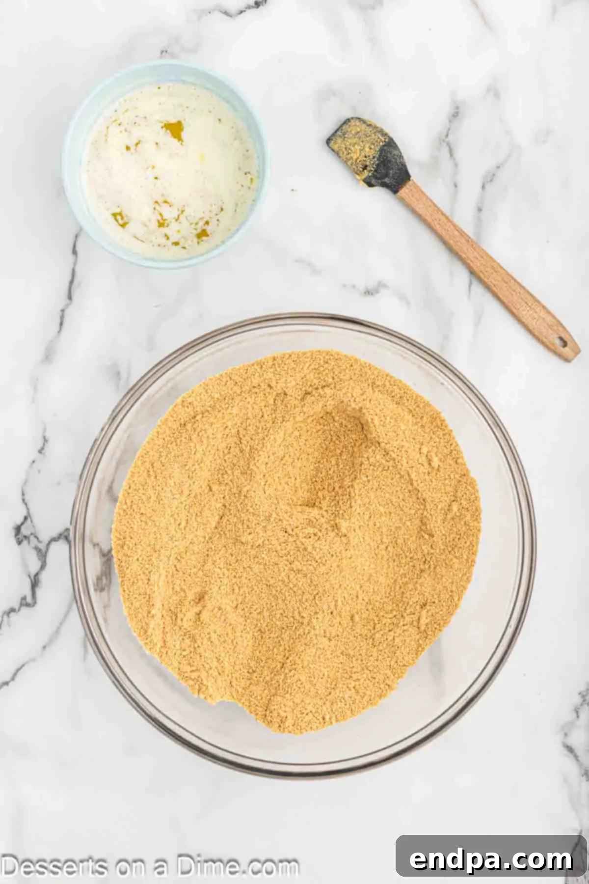 Golden Butter Pecan Cheesecake 6 A bowl filled with finely crushed graham cracker crumbs, ready to be mixed with butter and sugar for the cheesecake crust.