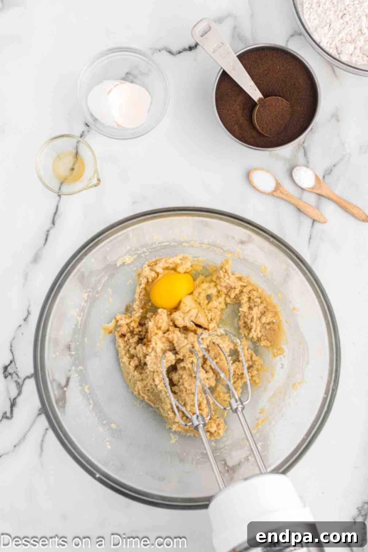 Espresso Delights 5 A large egg being mixed into the creamy butter and sugar mixture.