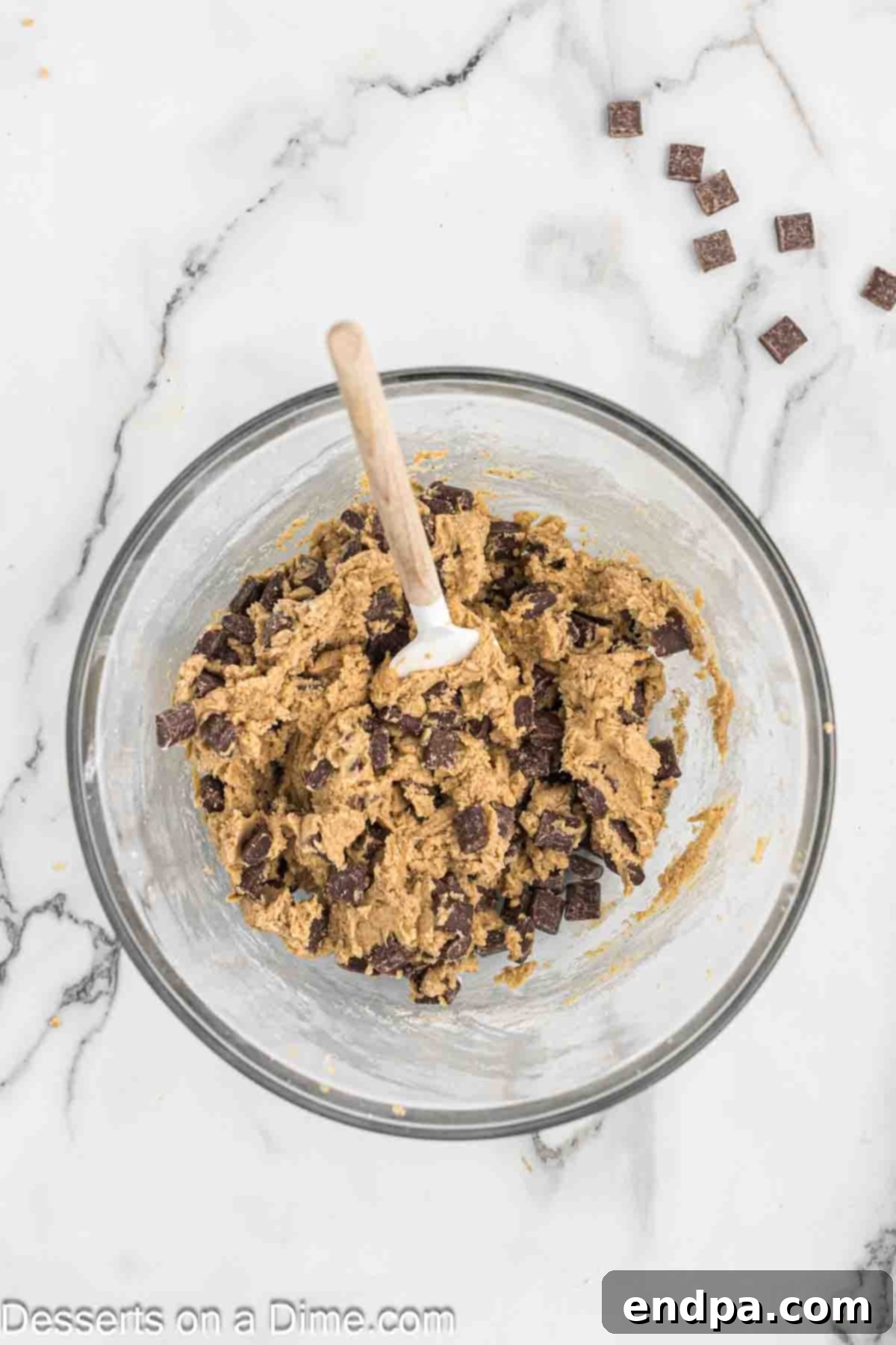 Espresso Delights 7 Semi-sweet chocolate chunks being carefully folded into the cookie dough with a spatula.
