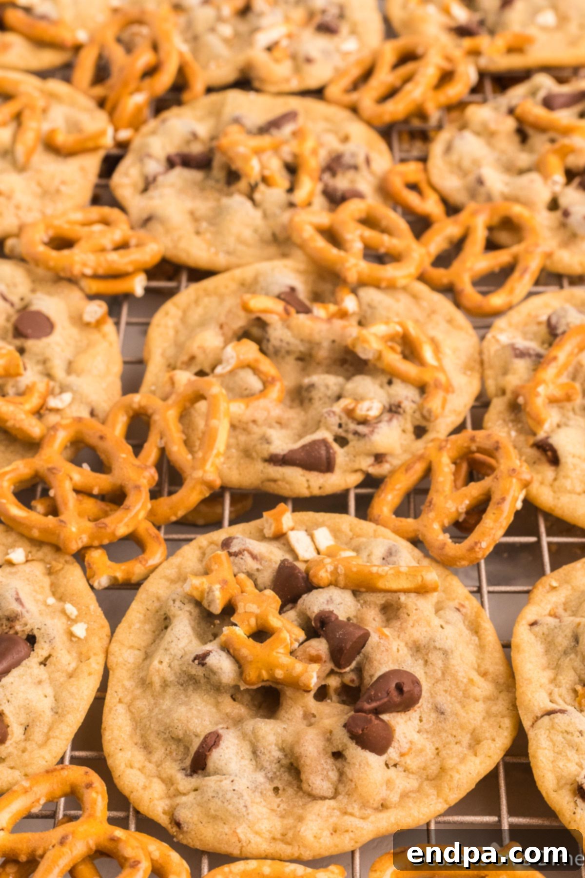 Freshly baked Chocolate Chip Pretzel Cookies cooling on a wire rack, ready to be enjoyed.