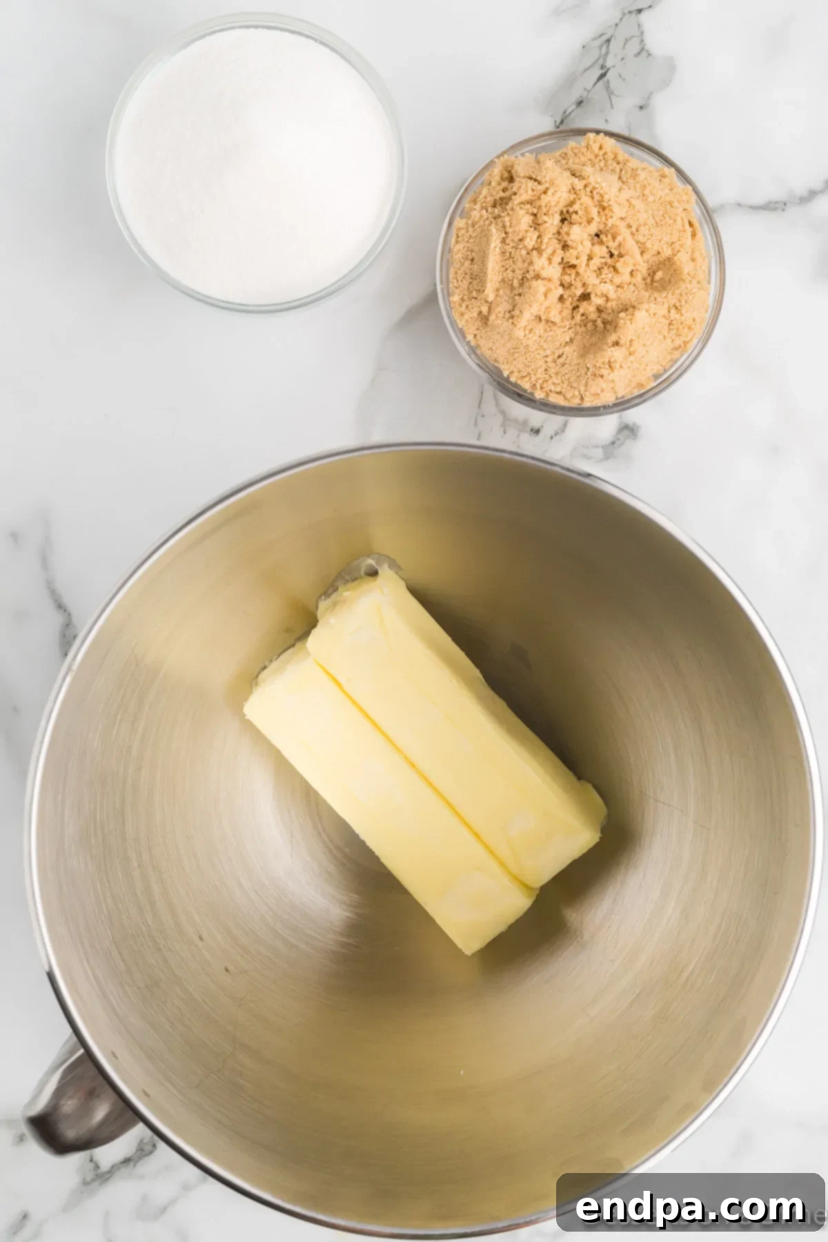 Softened butter in a mixing bowl, ready to be combined with sugar.