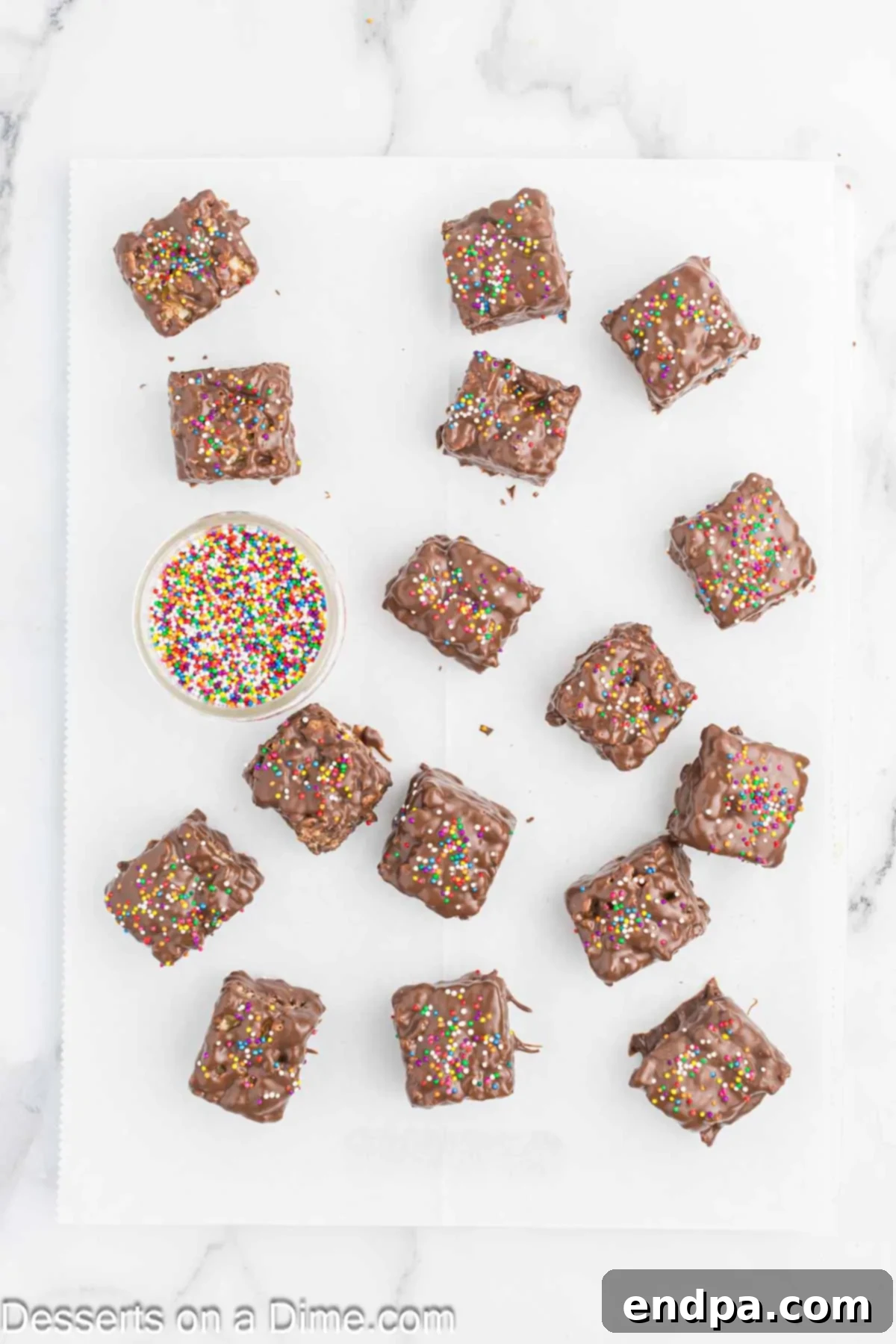 Chocolate covered Rice Krispie treats freshly topped with colorful sprinkles.