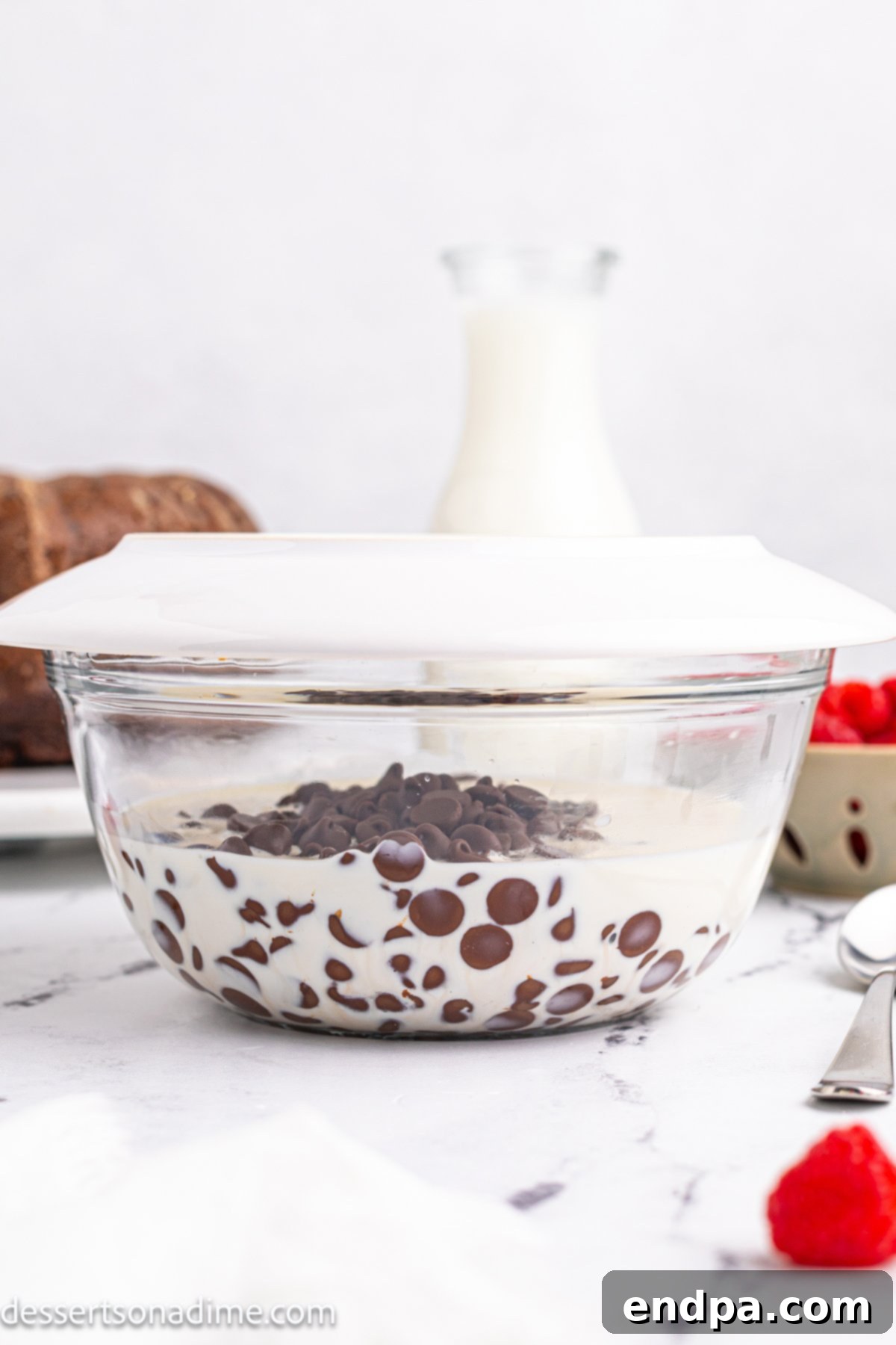Heavy whipping cream and chocolate chips in a microwave-safe bowl, ready for melting.