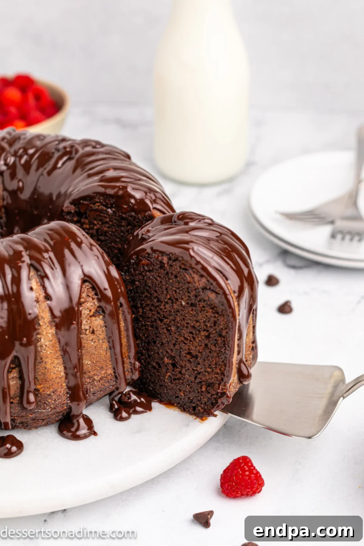A Chocolate Brownie Cake with ganache being sliced into servings, showcasing its rich, fudgy texture.