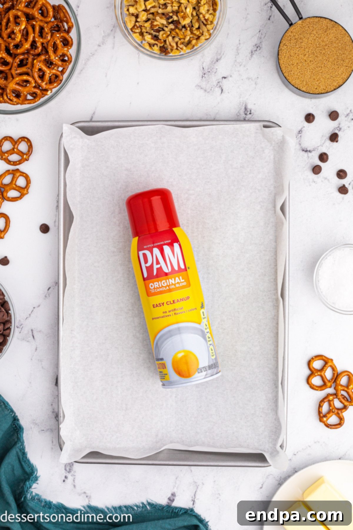 Twisted Toffee Treat 4 Baking sheet lined with parchment paper and sprayed with cooking spray, ready for pretzels.