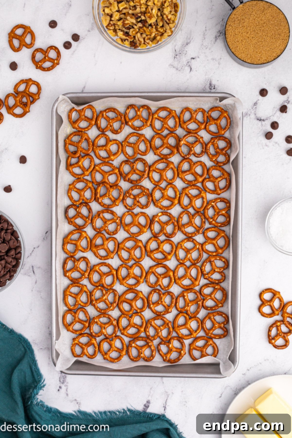 Twisted Toffee Treat 5 Mini pretzels spread in a single, even layer across the prepared baking sheet.
