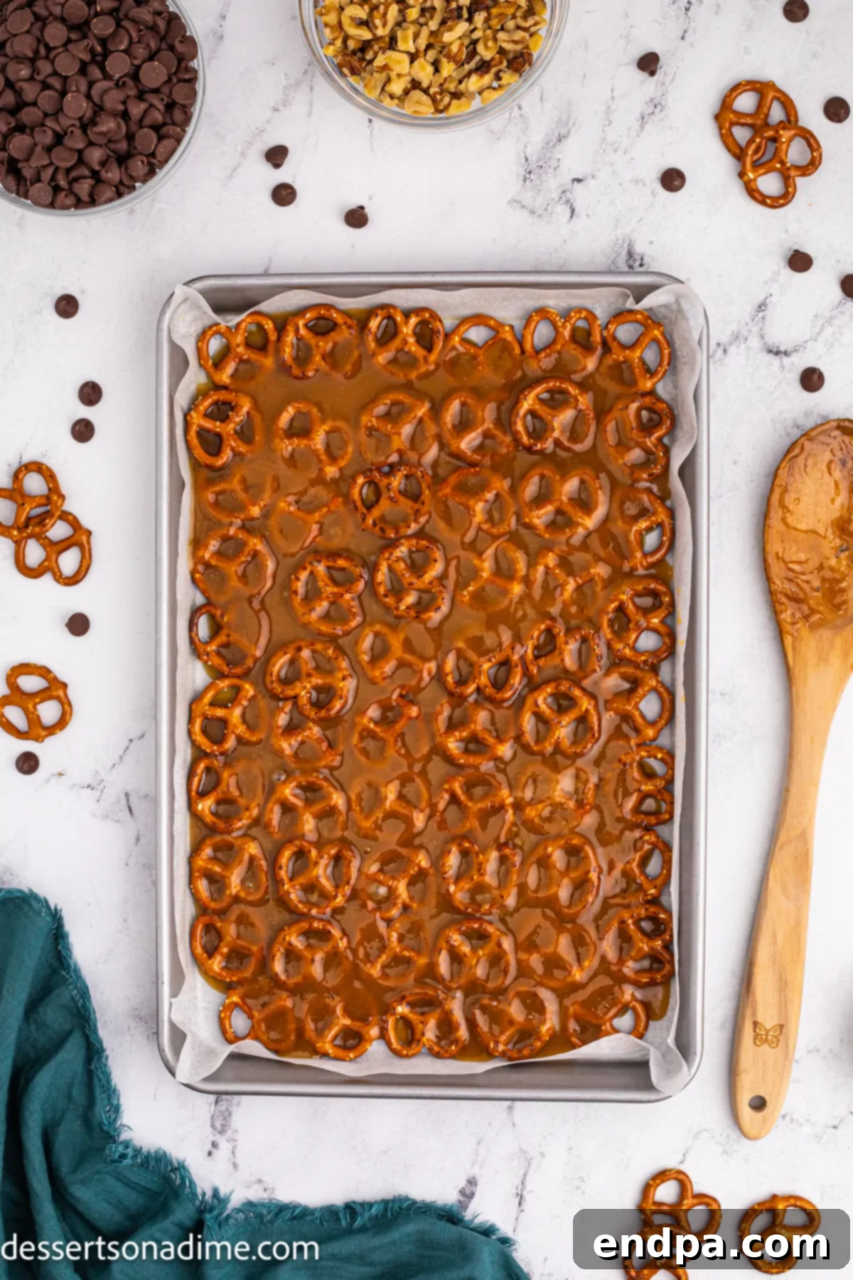 Twisted Toffee Treat 8 Bubbly brown sugar and butter mixture being poured evenly over the layer of pretzels on the baking sheet.