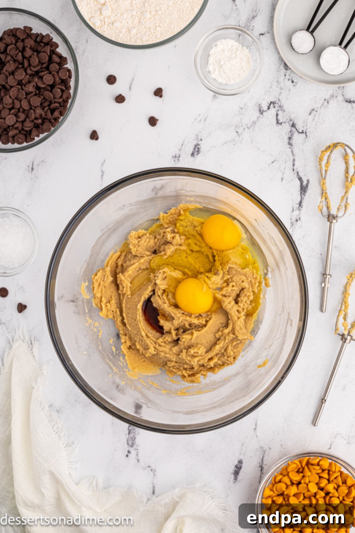 Eggs being added one by one to the creamy butter and sugar mixture.