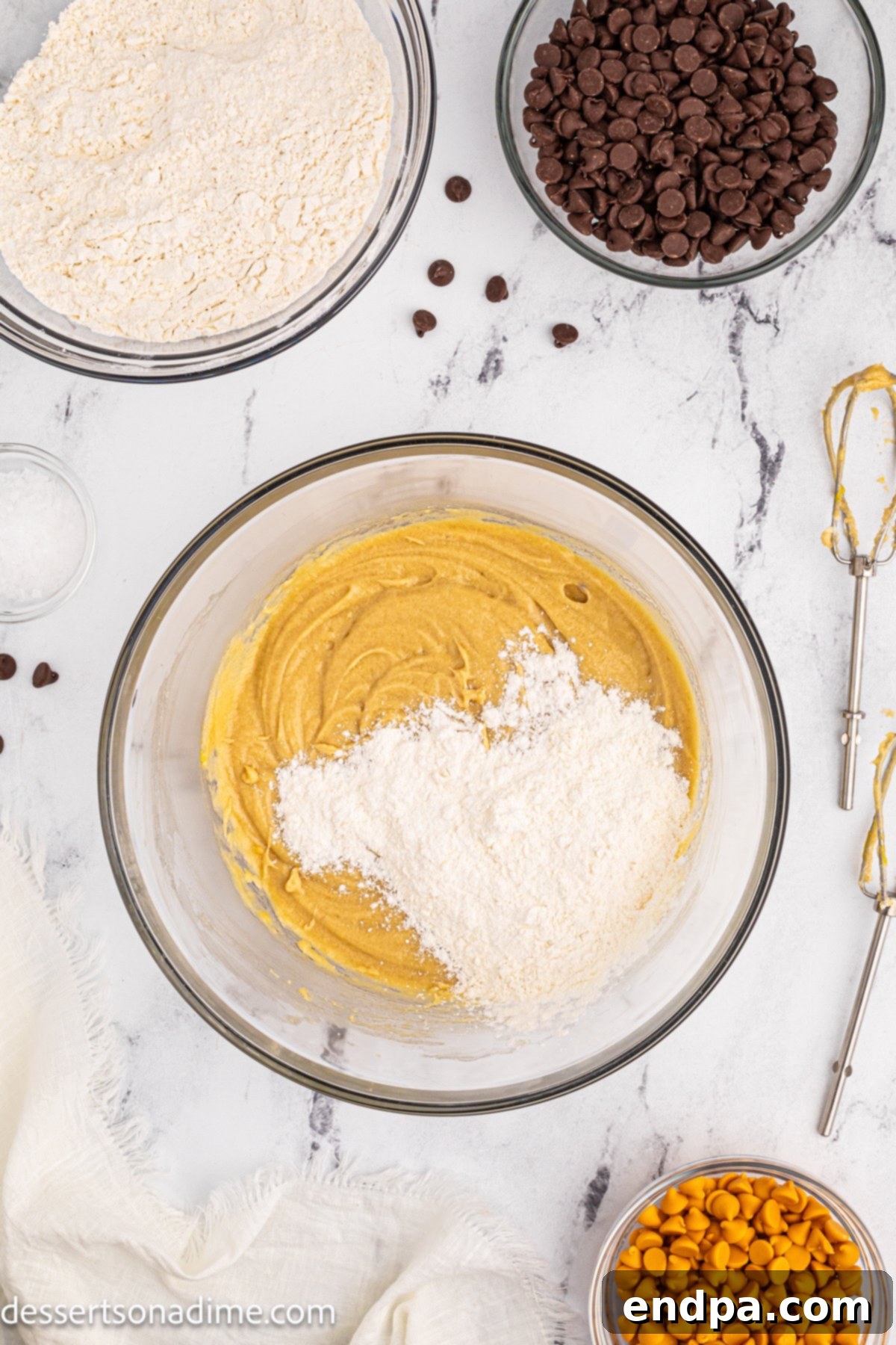 The dry flour mixture being slowly added to the wet ingredients in a mixing bowl.