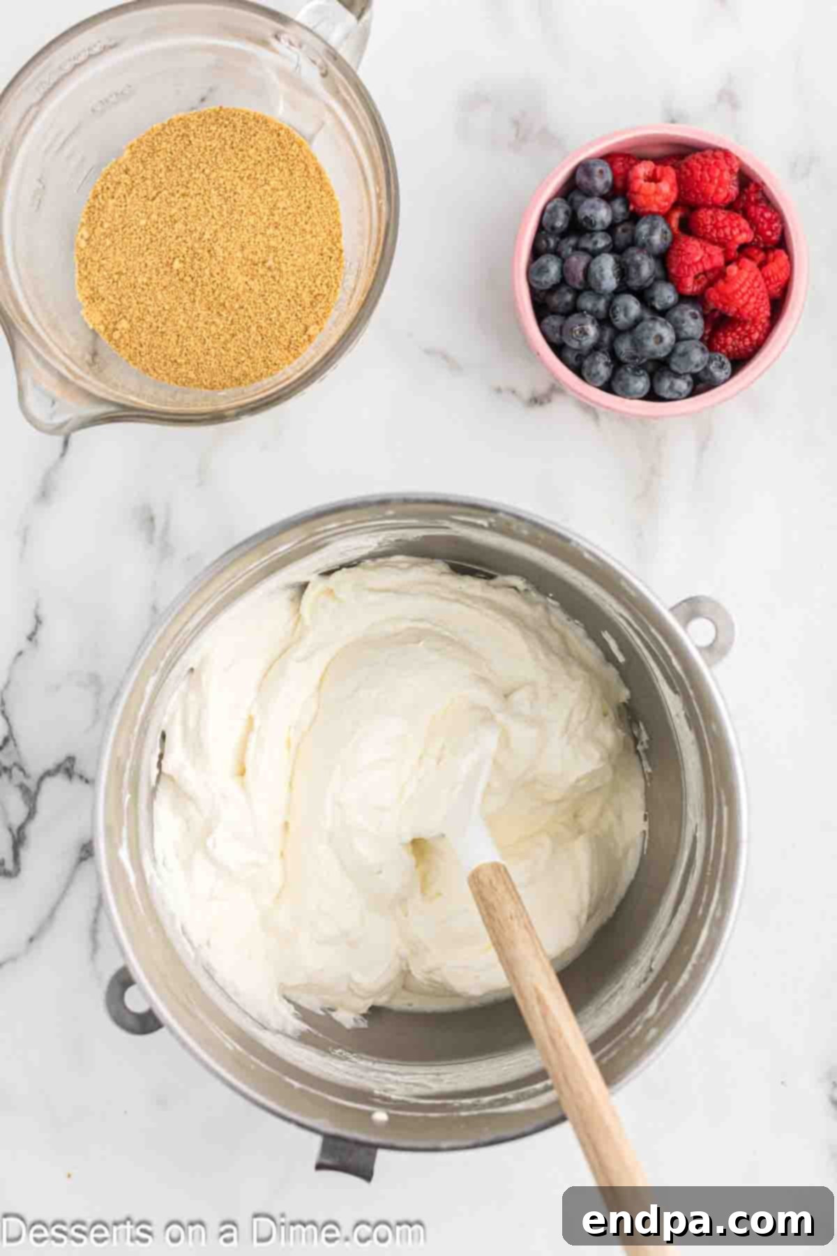 Sifted powdered sugar being slowly added to the cream cheese and sour cream mixture in the stand mixer.