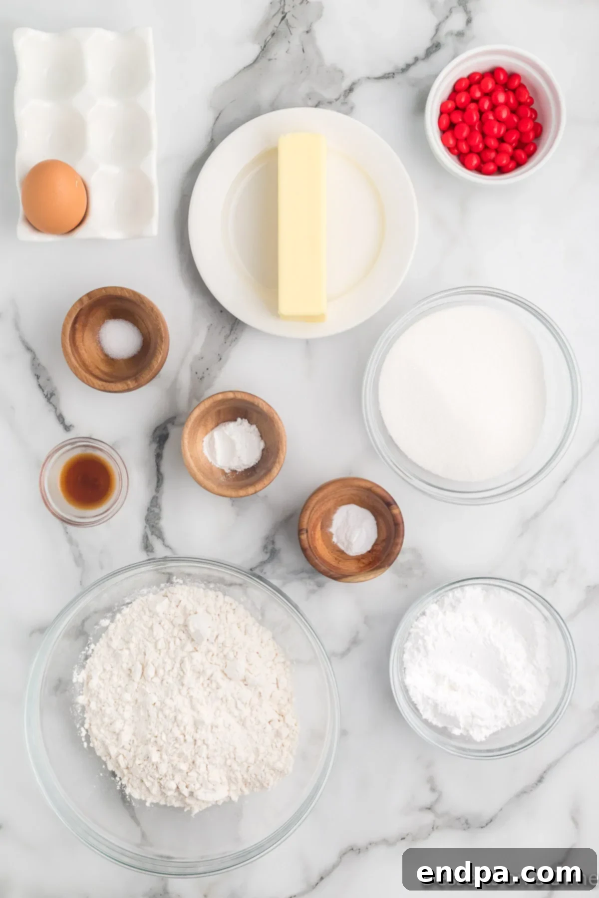 Sizzling Indulgences 3 A flat lay of all ingredients needed for red hot cookies, including red hot candies, butter, sugar, egg, vanilla, flour, baking soda, and powdered sugar, arranged neatly for clarity.