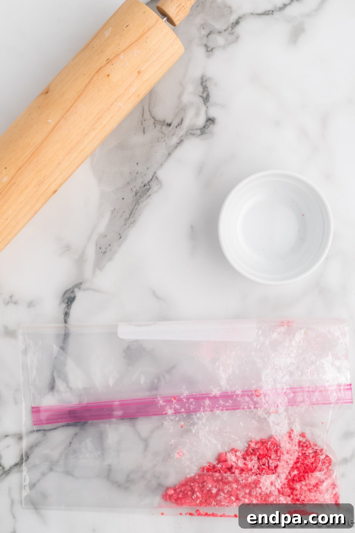 Sizzling Indulgences 4 Ziplock bag with red hot candies being crushed by a rolling pin.