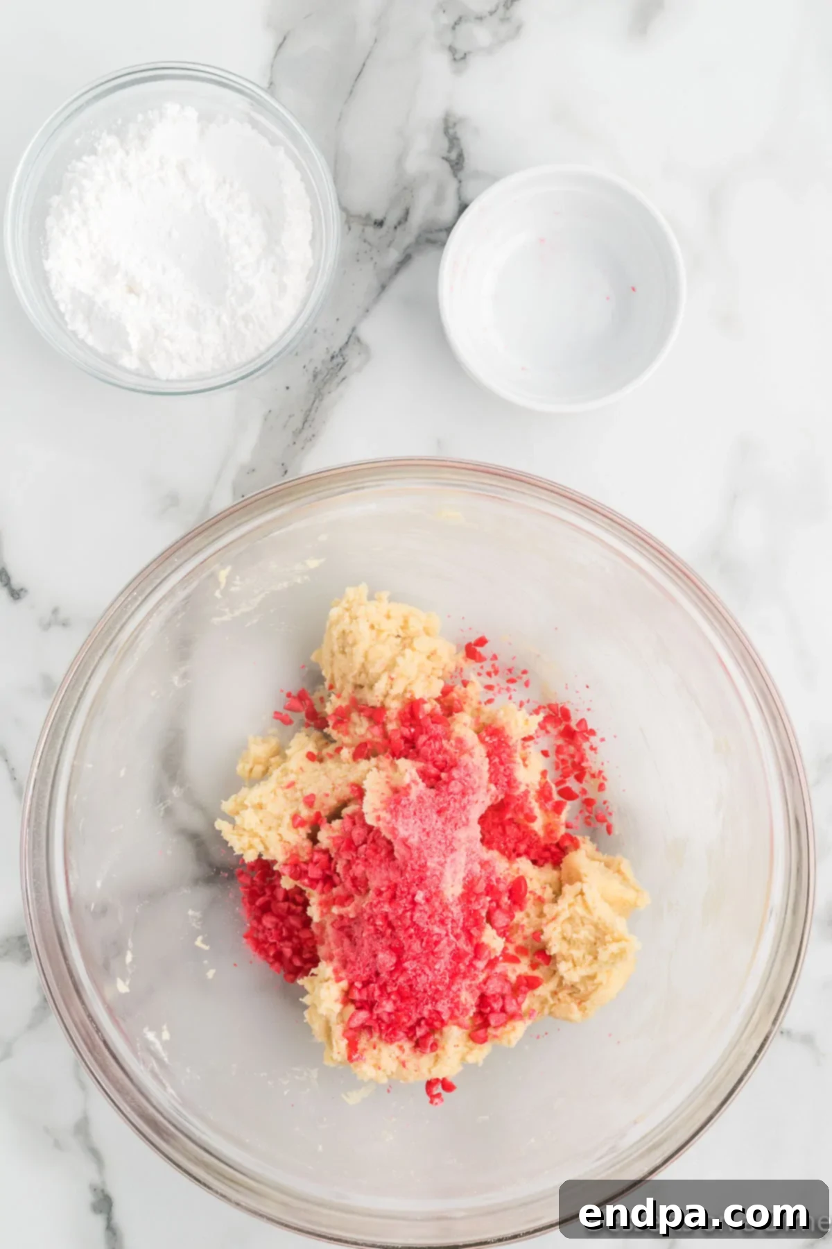 Sizzling Indulgences 7 Crushed red hot candies being gently folded into the cookie dough batter.