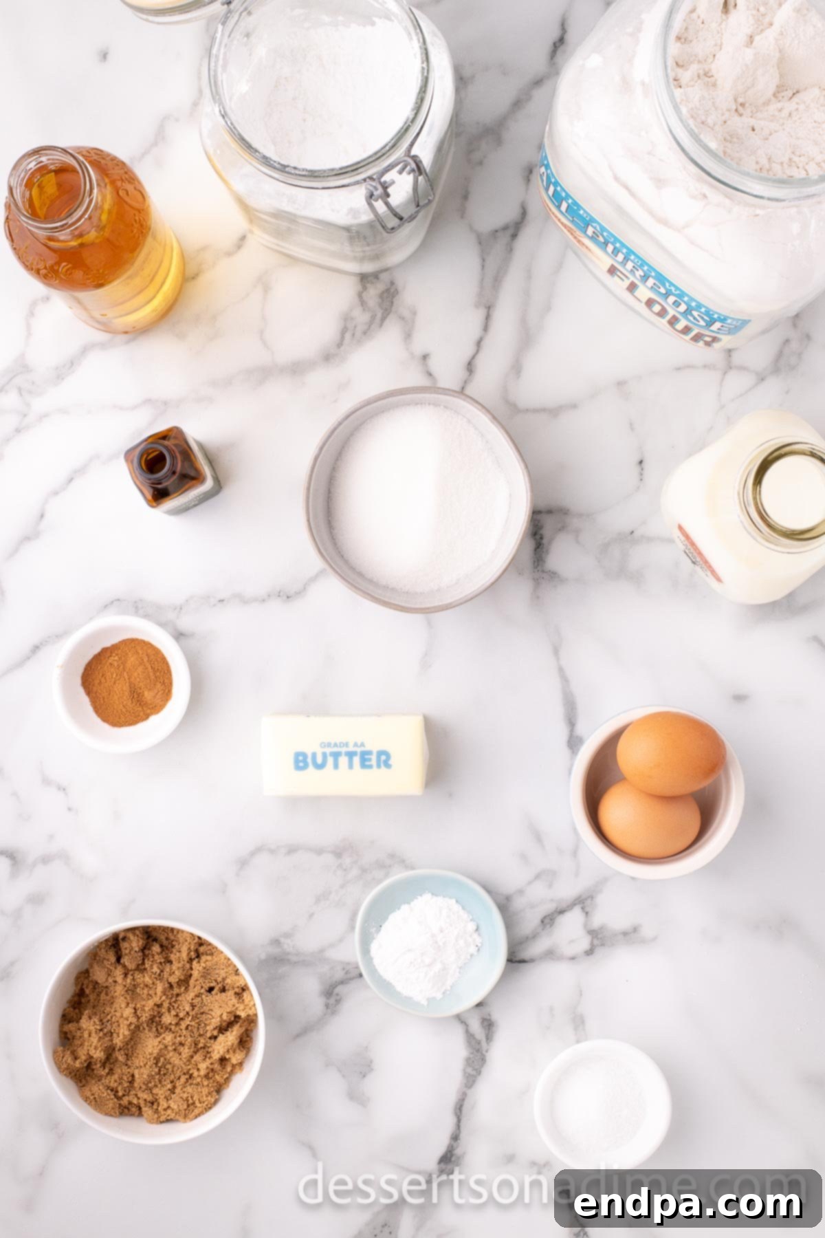 A flat lay image showing all the ingredients for Apple cider cupcakes: butter, sugar, eggs, vanilla, apple cider, and flour.