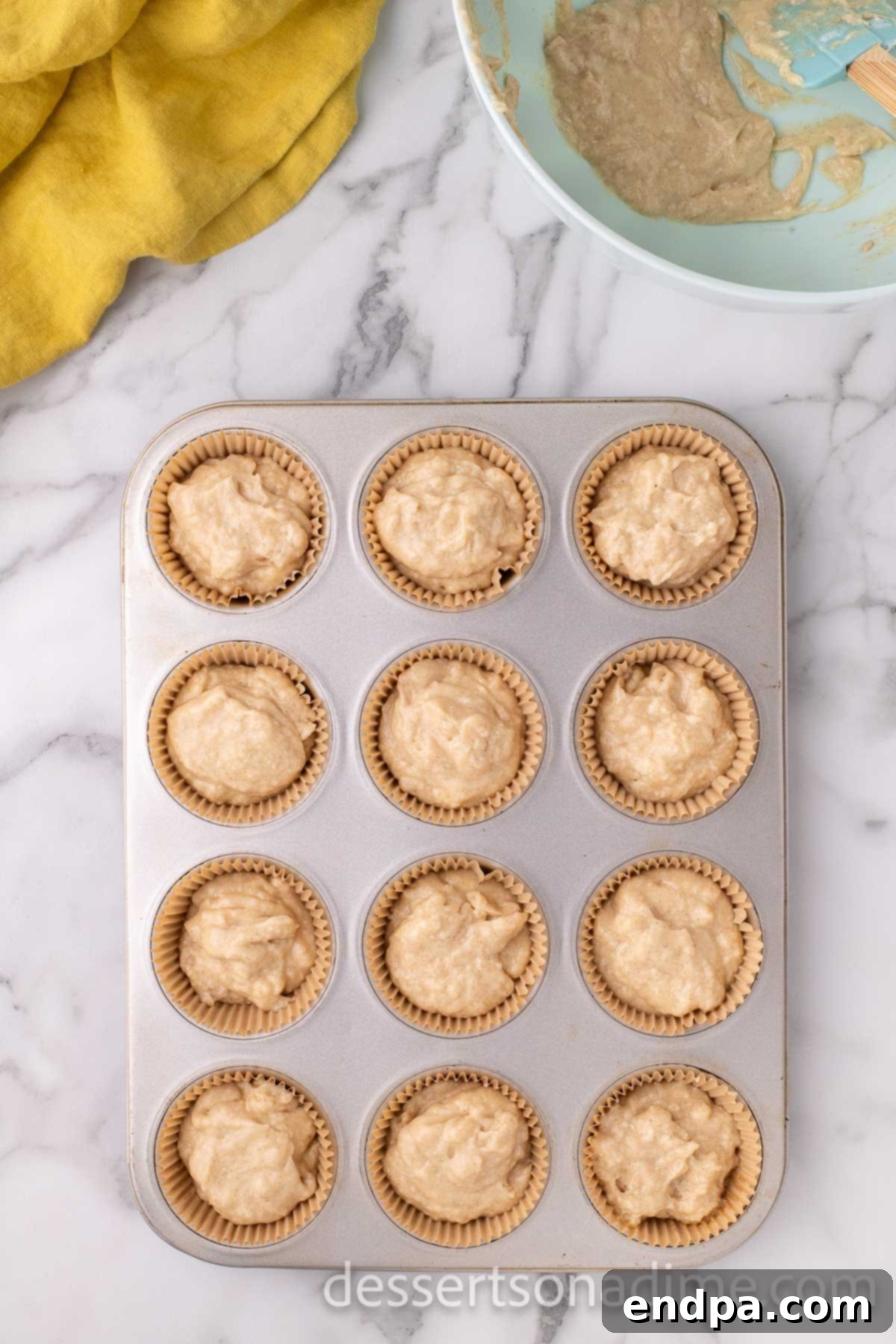 Cupcake batter neatly scooped into muffin tins, ready for baking.