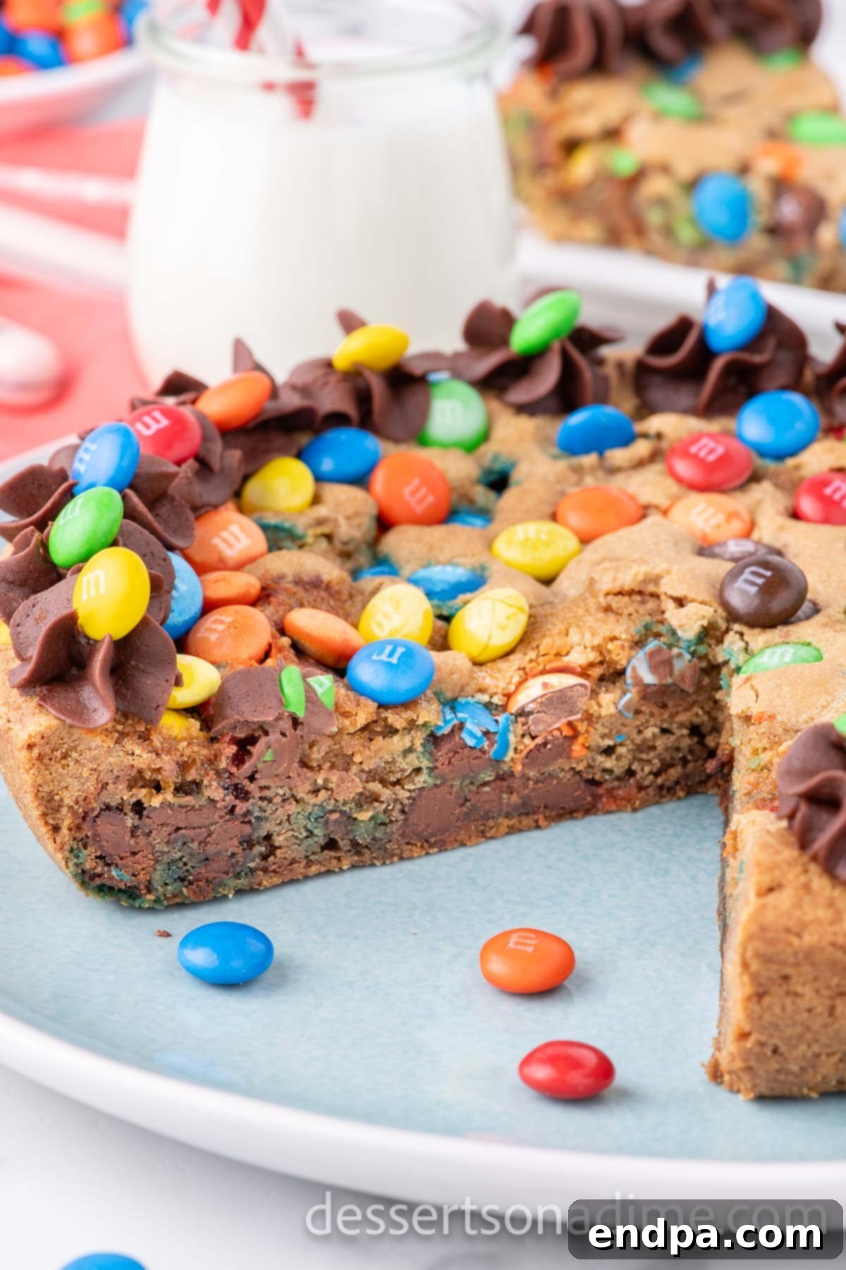 M&M cookie cake sliced on a platter.