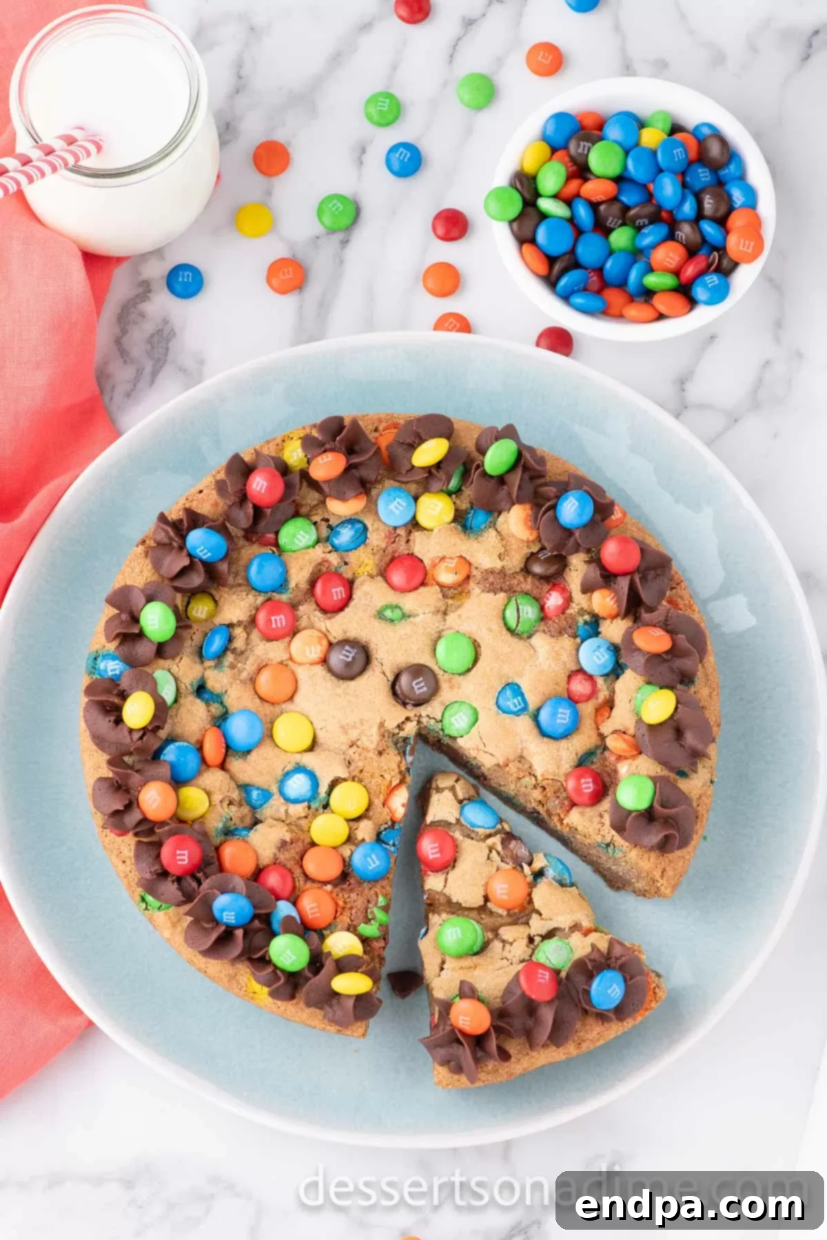 M&M cookie cake sliced on a platter.