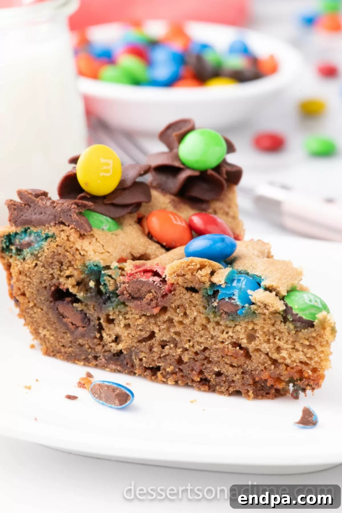 M&M cookie cake sliced on a platter.