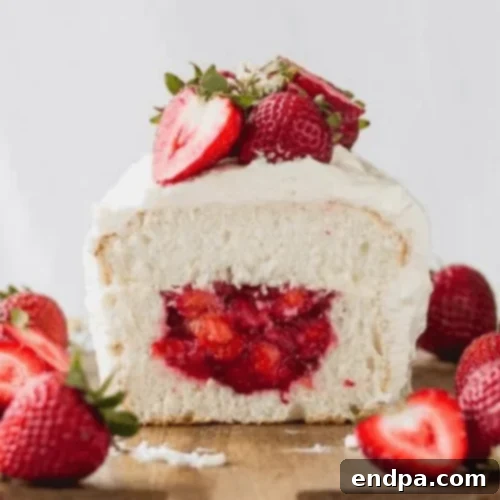 Angel Food Cake with Strawberry Filling, an airy loaf cake filled with fresh strawberries and frosted with whipped cream.
