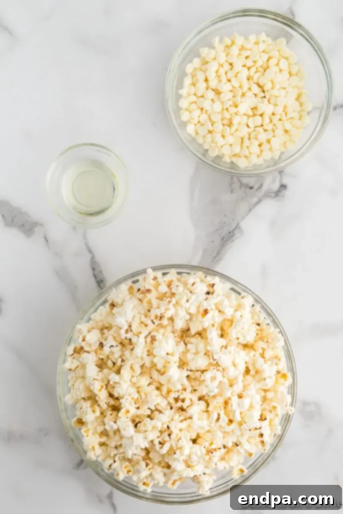 A simple arrangement of the three main ingredients for white chocolate popcorn: unpopped kernels, white chocolate chips, and vegetable oil.