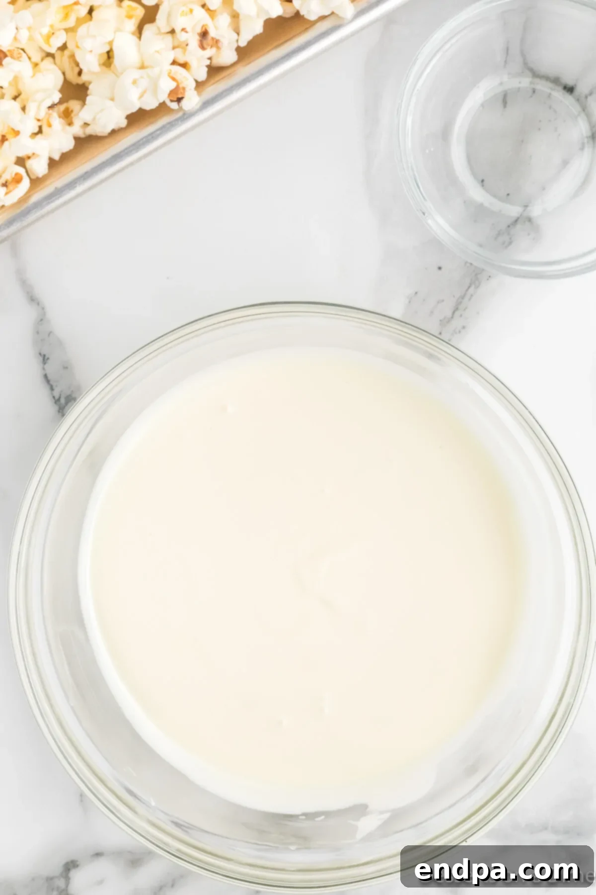 A microwave-safe bowl with perfectly melted and creamy white chocolate, ready for drizzling.