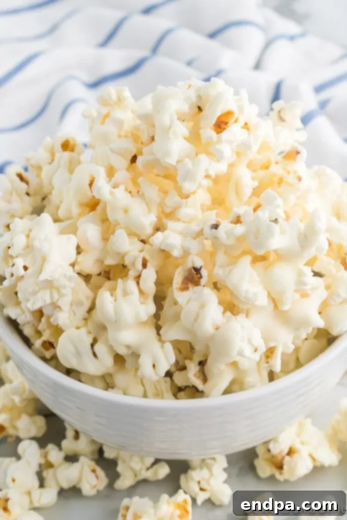 A close-up shot of a bowl brimming with delectable White Chocolate Popcorn, highlighting the even coating and inviting texture.